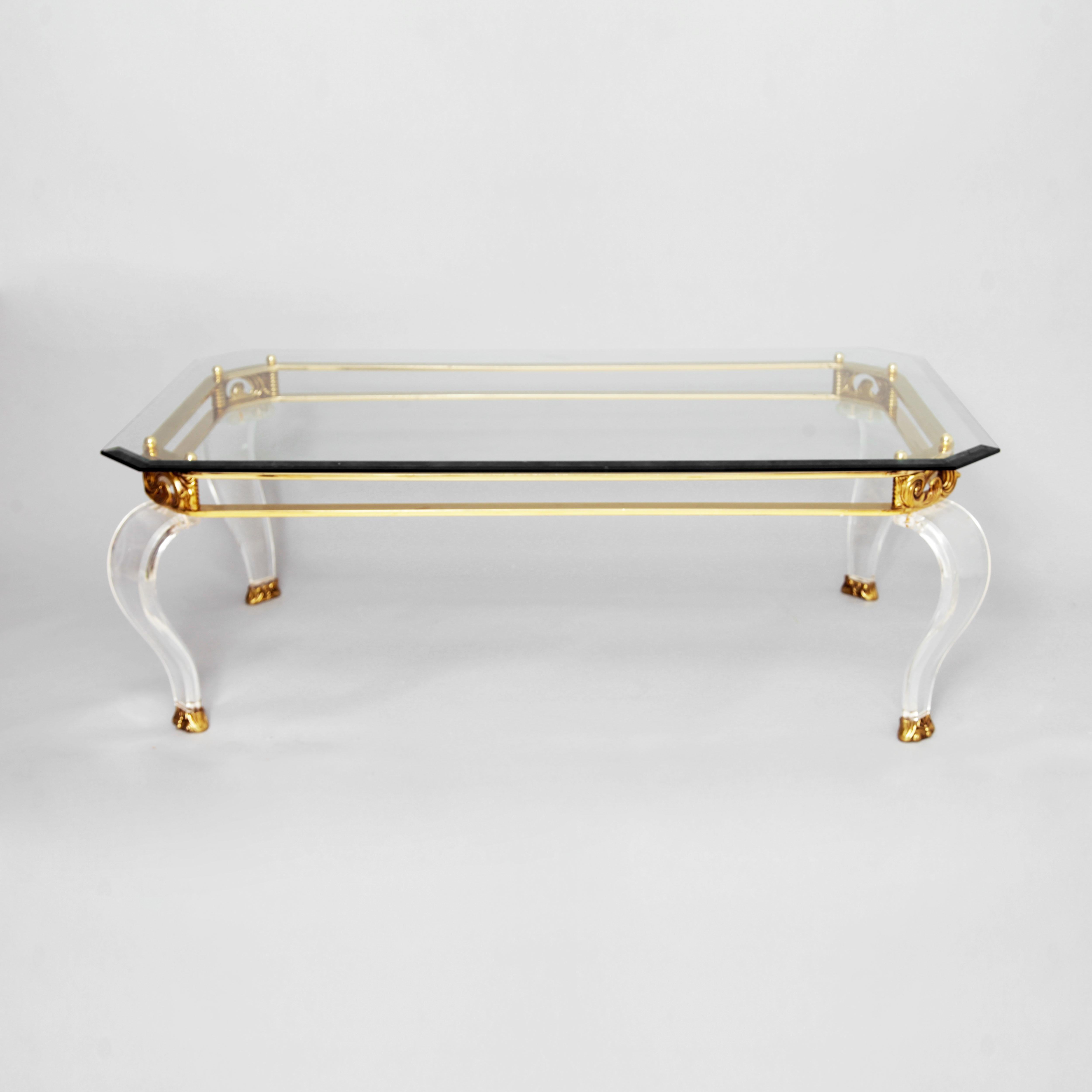 Intricate brass and curved Lucite legs rectangular coffee table. Clear octagonal glass top.