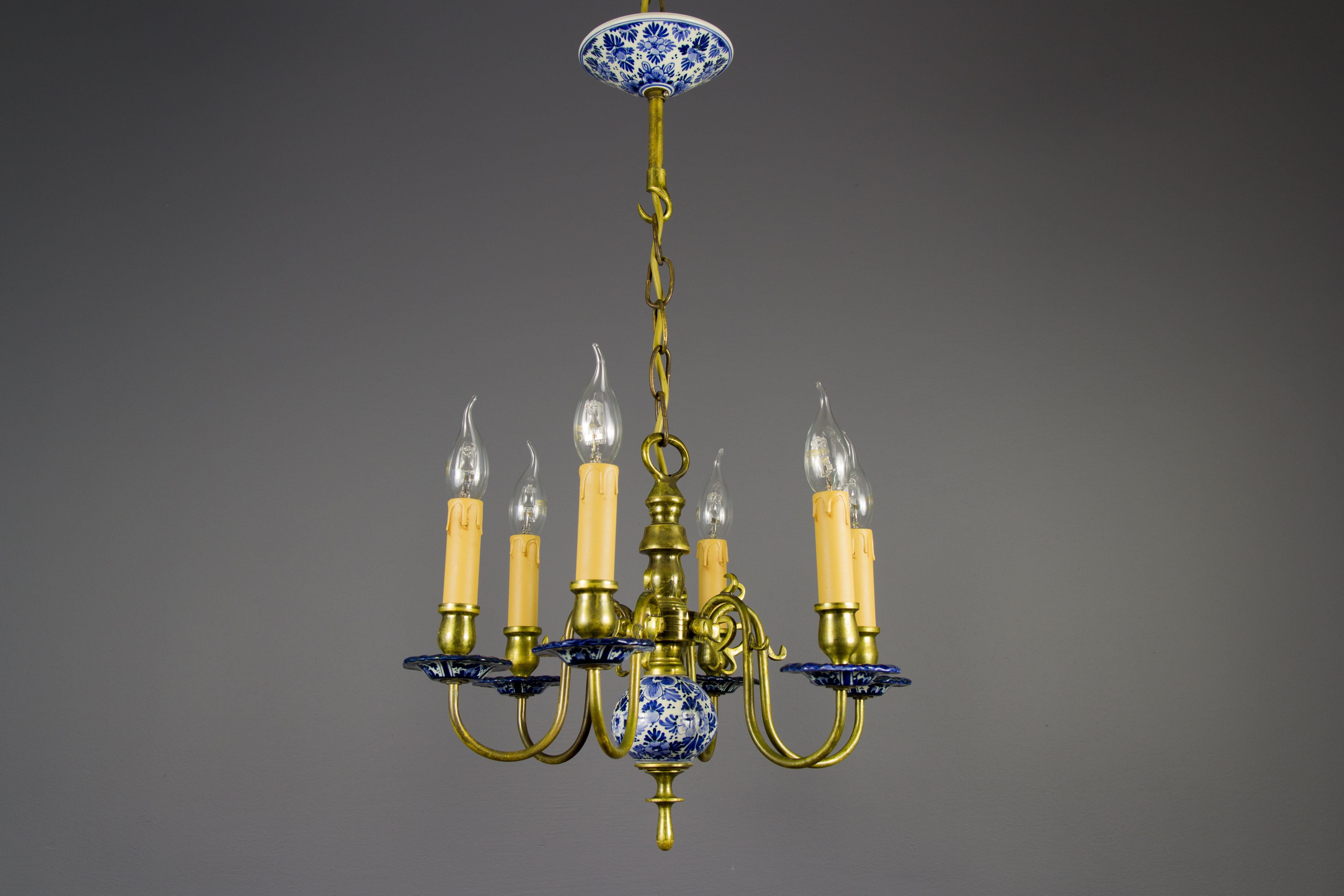 Elegant brass and blue and white Delft porcelain chandelier. Six brass arms with sockets for E14 size light bulbs. The inside of the canopy is marked with the D. P. Delft.
Dimensions: Diameter 45 cm / 17.71 in, height 70 cm / 27.55 in.
 