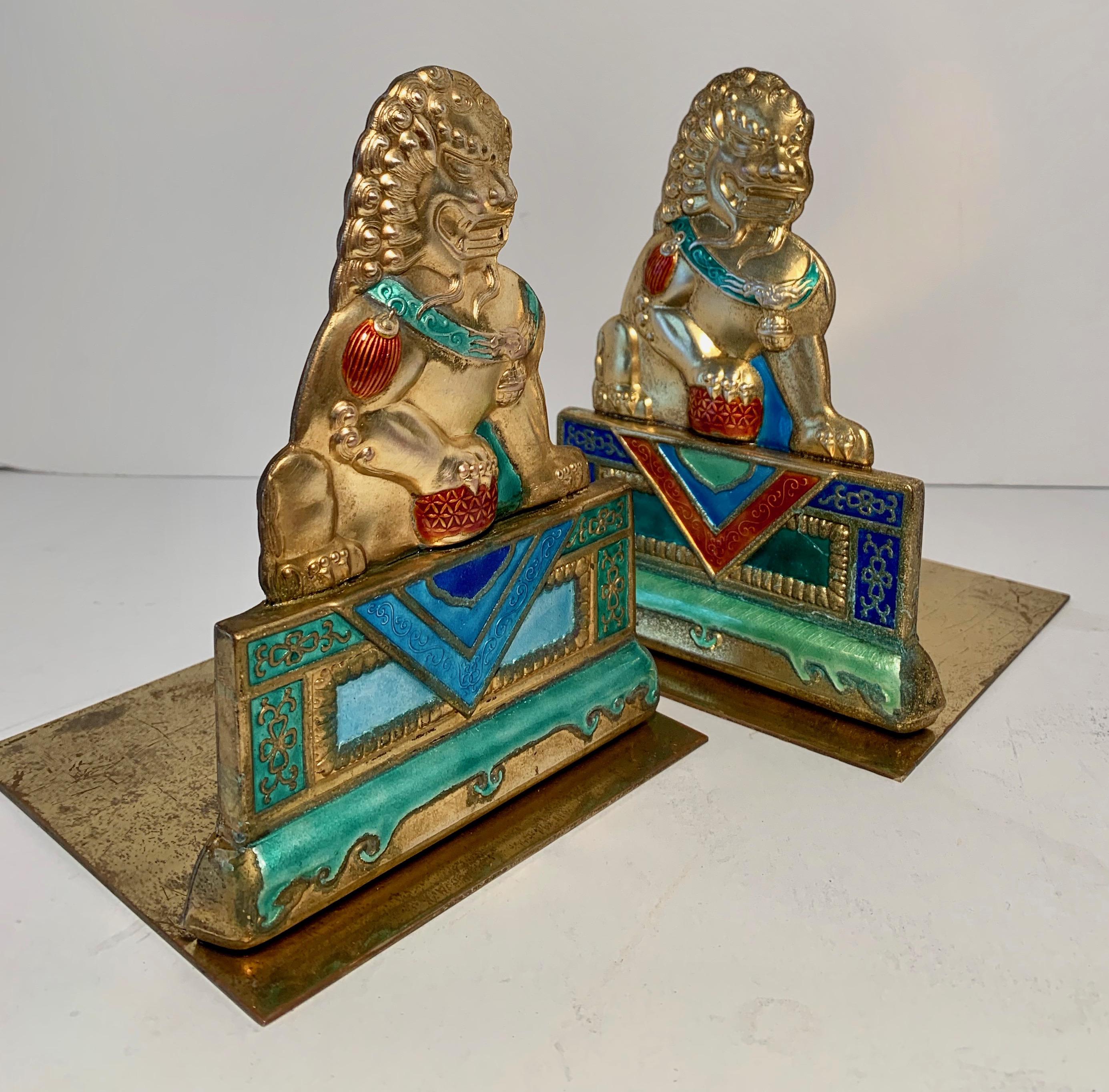 A lovely and vibrant pair of brass bookends with Foo Dog repousse in brilliant enamel colors - well suited for any room and lovely for the Childs room