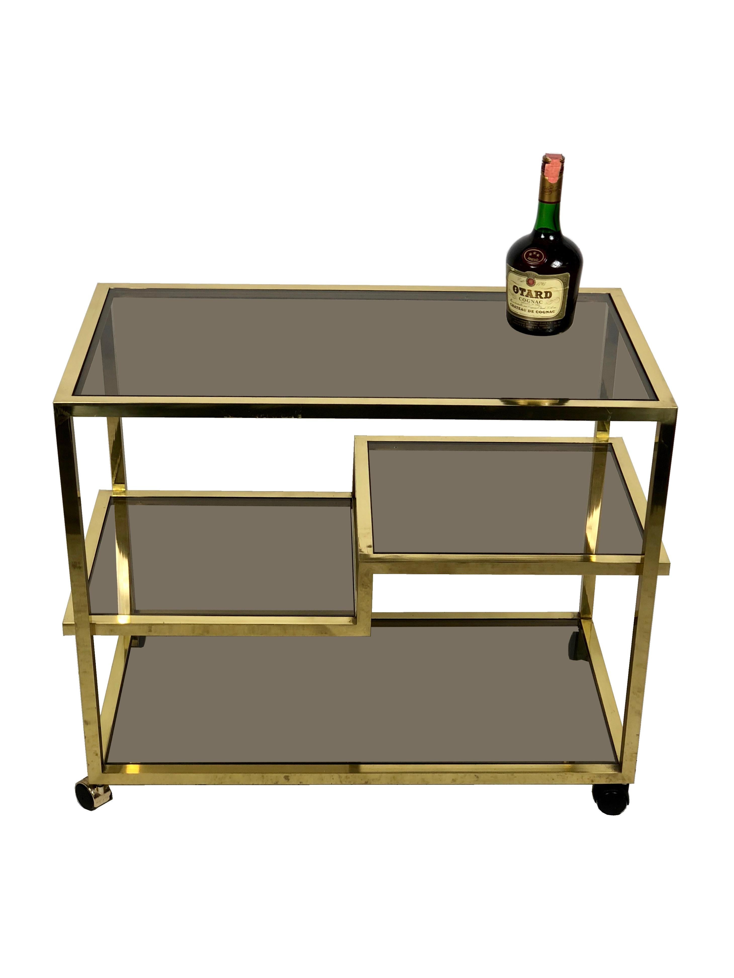 This vintage brass serving cart features unique midcentury design, combining simple lines and plenty of room for storage or service. Attributed to the Italian designer Romeo Rega.
