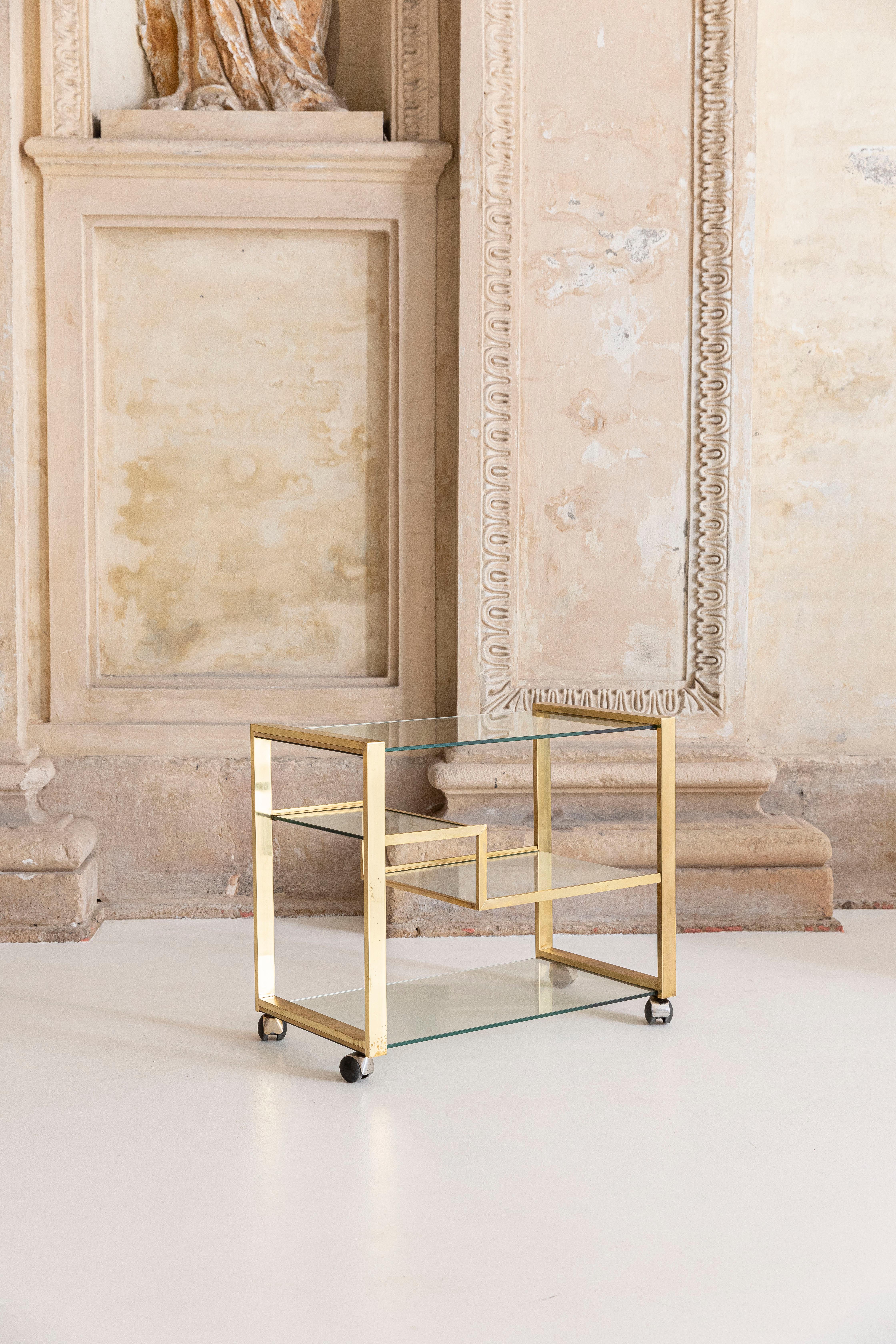 Elegant brass and glass bar cart with 4 glass shelves, sculptural tires.
Gabriella Crespi inspired.