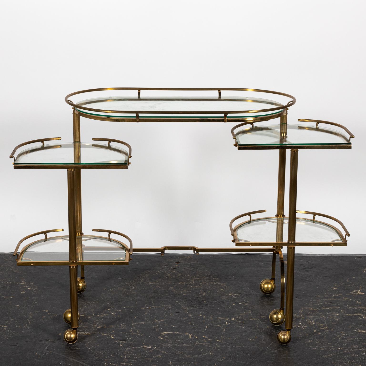 Brass and glass bar cart with movable sides that open up into additional shelves. Please note of wear consistent with age including patina and oxidation to the Brass frame.