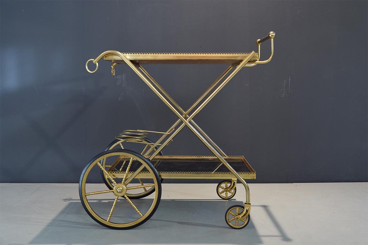 Brass and glass bar cart, drinks or serving trolley by renowned French design house Maison Baguès. There's room for three bottles in the bottle holders. Amazing decorative piece.