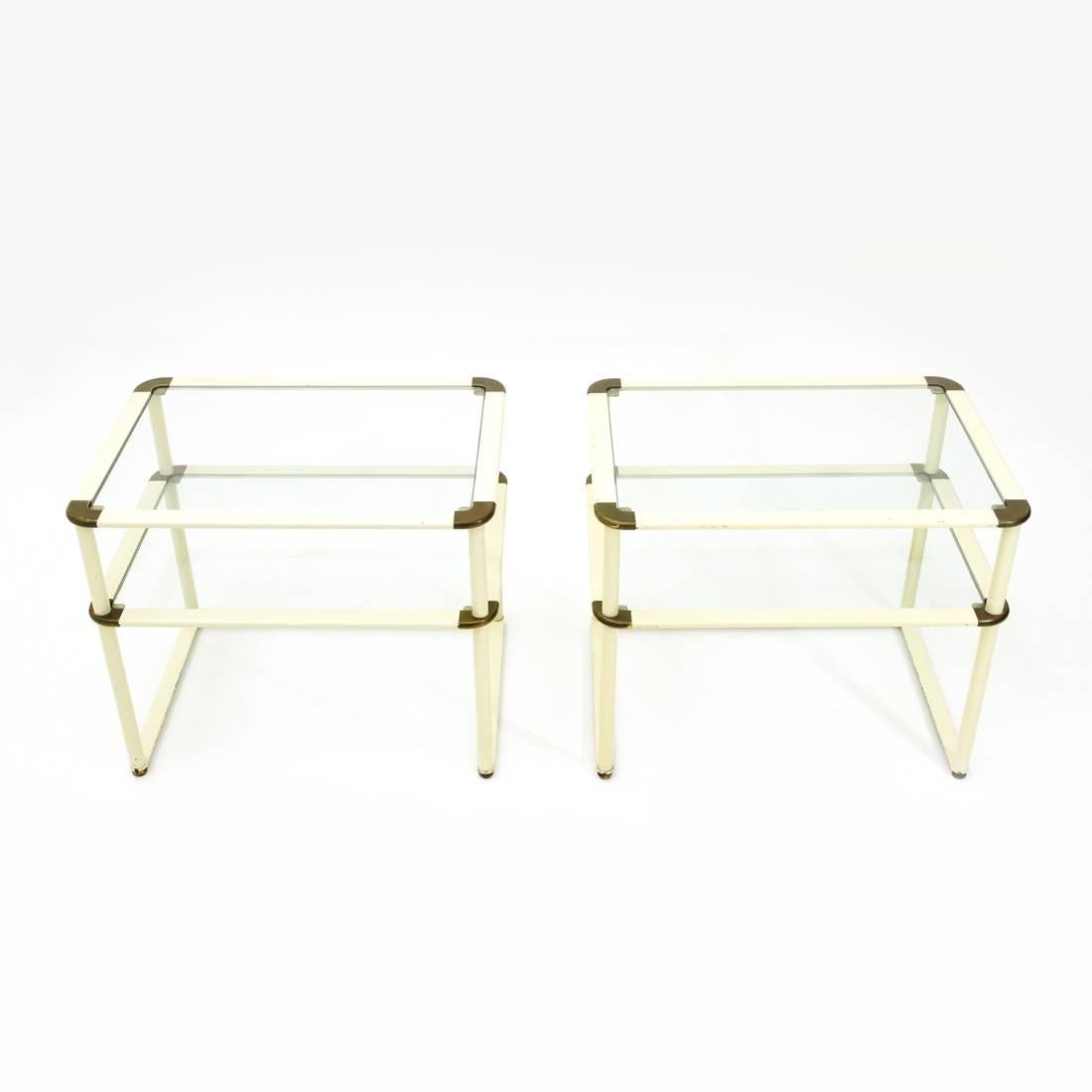 Pair of bedside tables of Italian manufacture of the 1980s.
Structure in brass and white painted metal.
Two glass tops.
Foot with hexagonal shape in brass.
Structure in good condition, some signs due to normal use over time.

Dimensions: Width