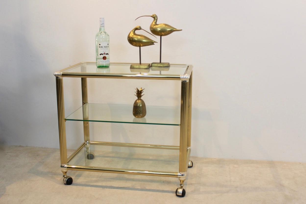 Superbe chariot de bar belge en laiton et verre avec verre transparent trempé. Le cadre en métal lourd a une finition d'origine totale en laiton avec des bords argentés avec un peu de patine. La table comporte trois niveaux, celui du milieu étant