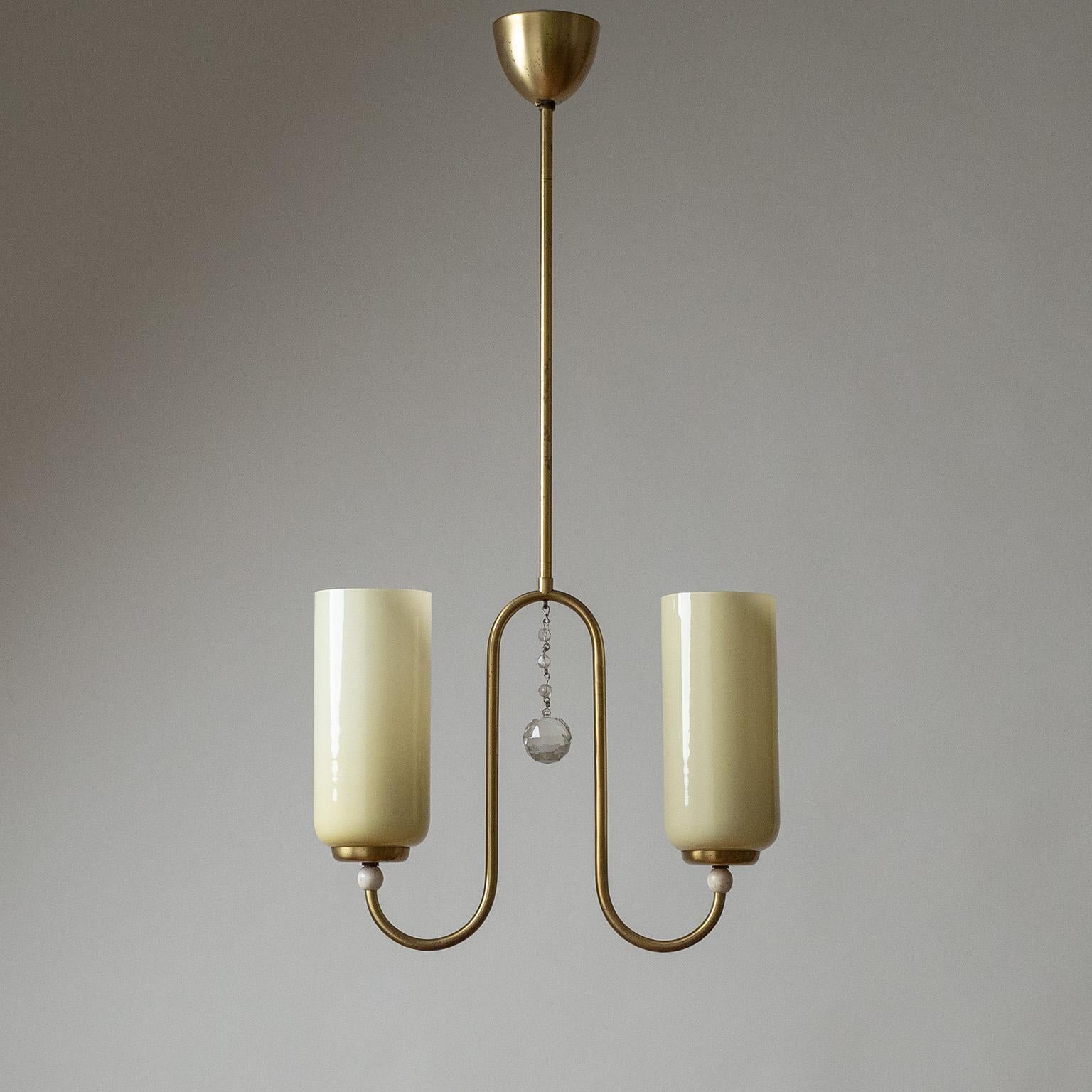 Sublime brass and glass Art Deco chandelier from the 1930s. Two undulating brass arms with tall ivory-colored blown glass diffusers. In between these is a cut crystal glass detail. Very nice original condition with some age-related patina on the