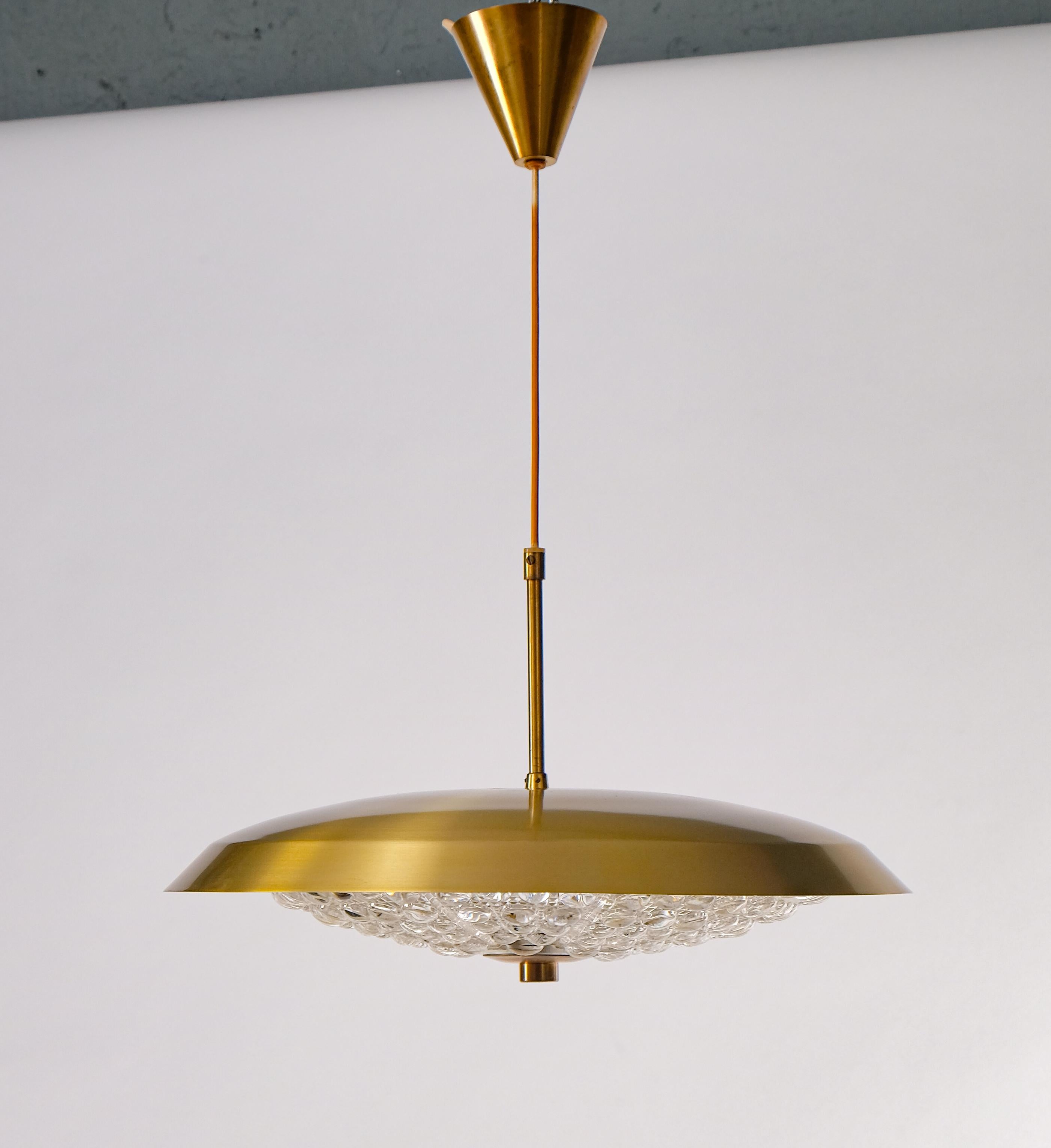 Swedish glass and brass pendant designed by Carl Fagerlund for Orrefors, 1960s.
Diameter: 50 cm 
Height is adjustable.


