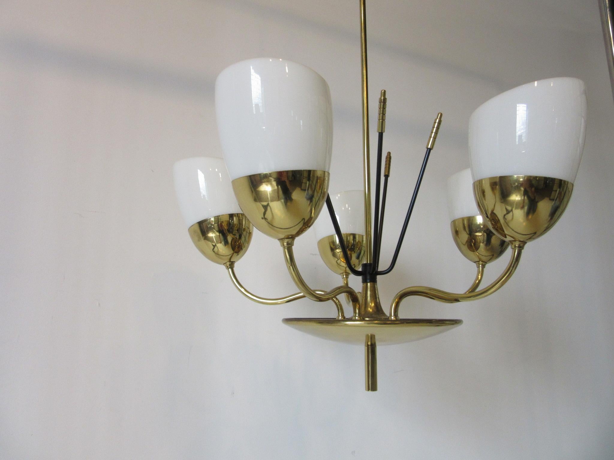 A fine and well crafted brass and milk glass chandelier with six arms, removable shades and detailed stems that come out of the base. Retains the manufactures label made by the Majestic M.S.& S. Company New York. Formally the Majestic Lamp and radio
