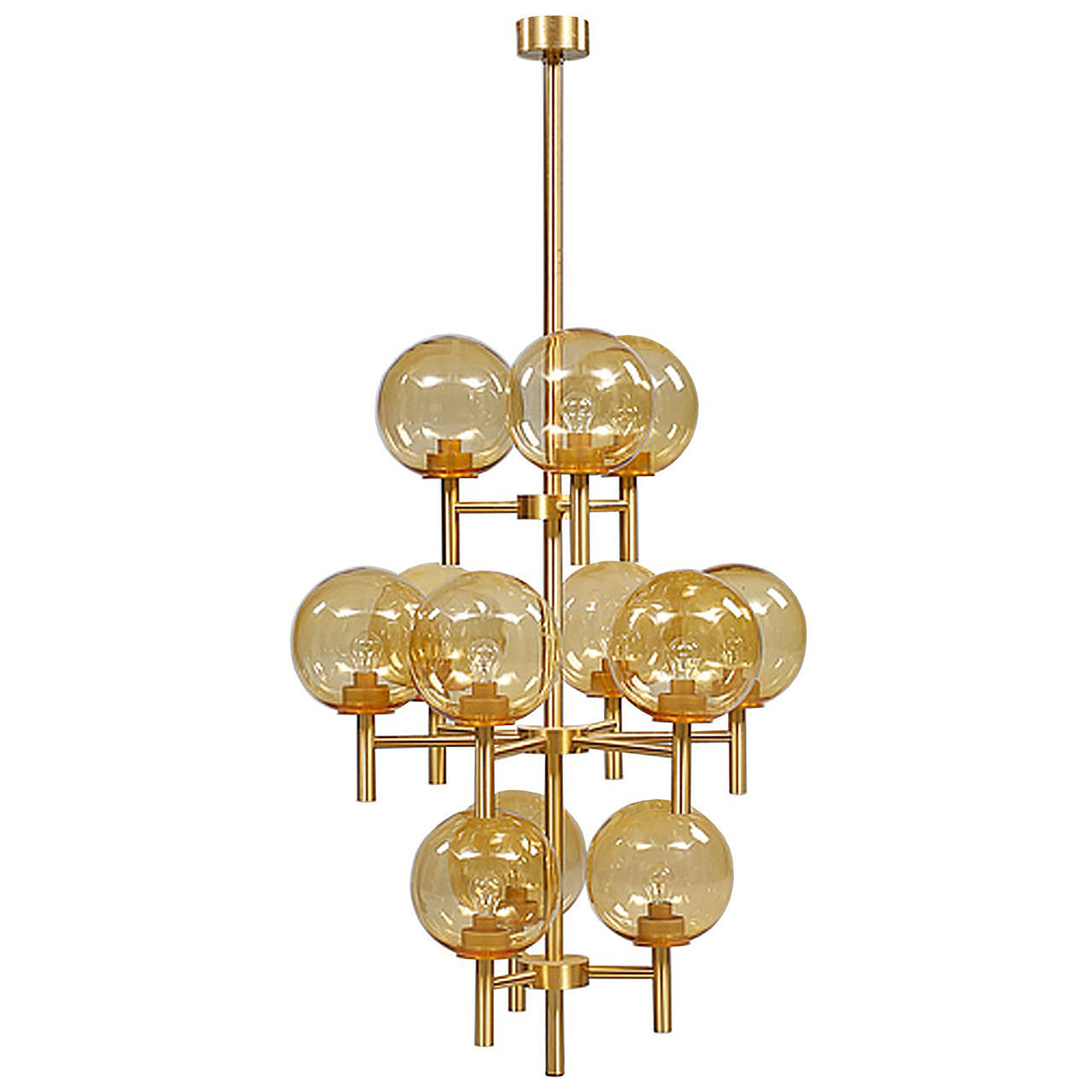 A brass chandelier with multiple amber globes by Uno & Osten Kristiansson.

 Swedish, Circa 1970's

(Two (2) Chandeliers Available)

In stock.
