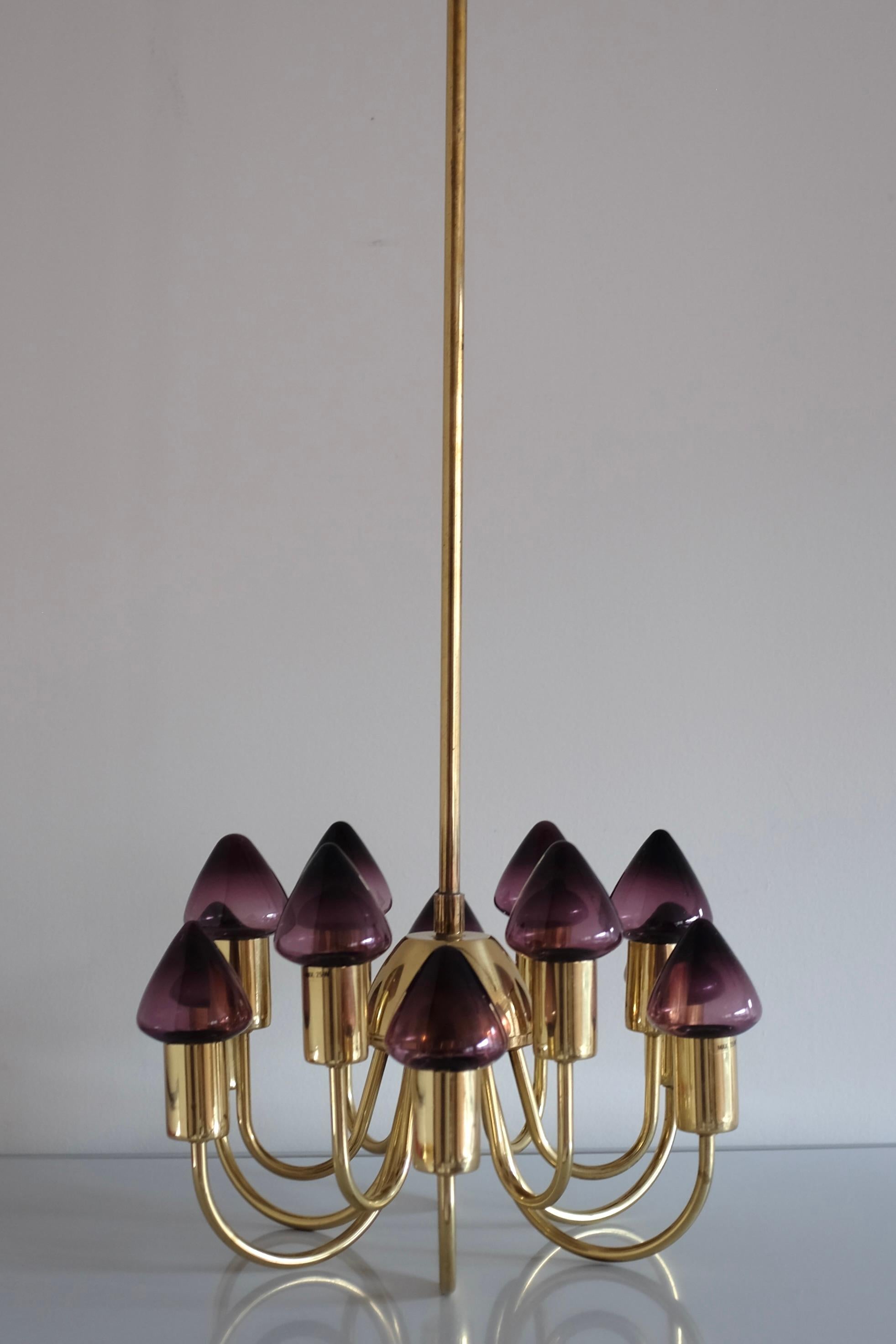 Stupendo lampadario in ottone e vetro di Hans-Agne Jakobsson degli anni '60 circa, con dodici lanterne viola soffiate a mano. L'altezza del braccio della lampada in ottone può essere estesa con un braccio aggiuntivo per misurare un'altezza totale di