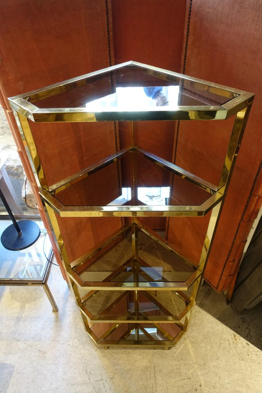 Gorgeous, elegant og sophisticated French corner shelves. Brass with five shelves – four of which are a pale smokey glass, and the bottom one being a mirror. A practical and stunning piece. Optimal storage space using an otherwise unused