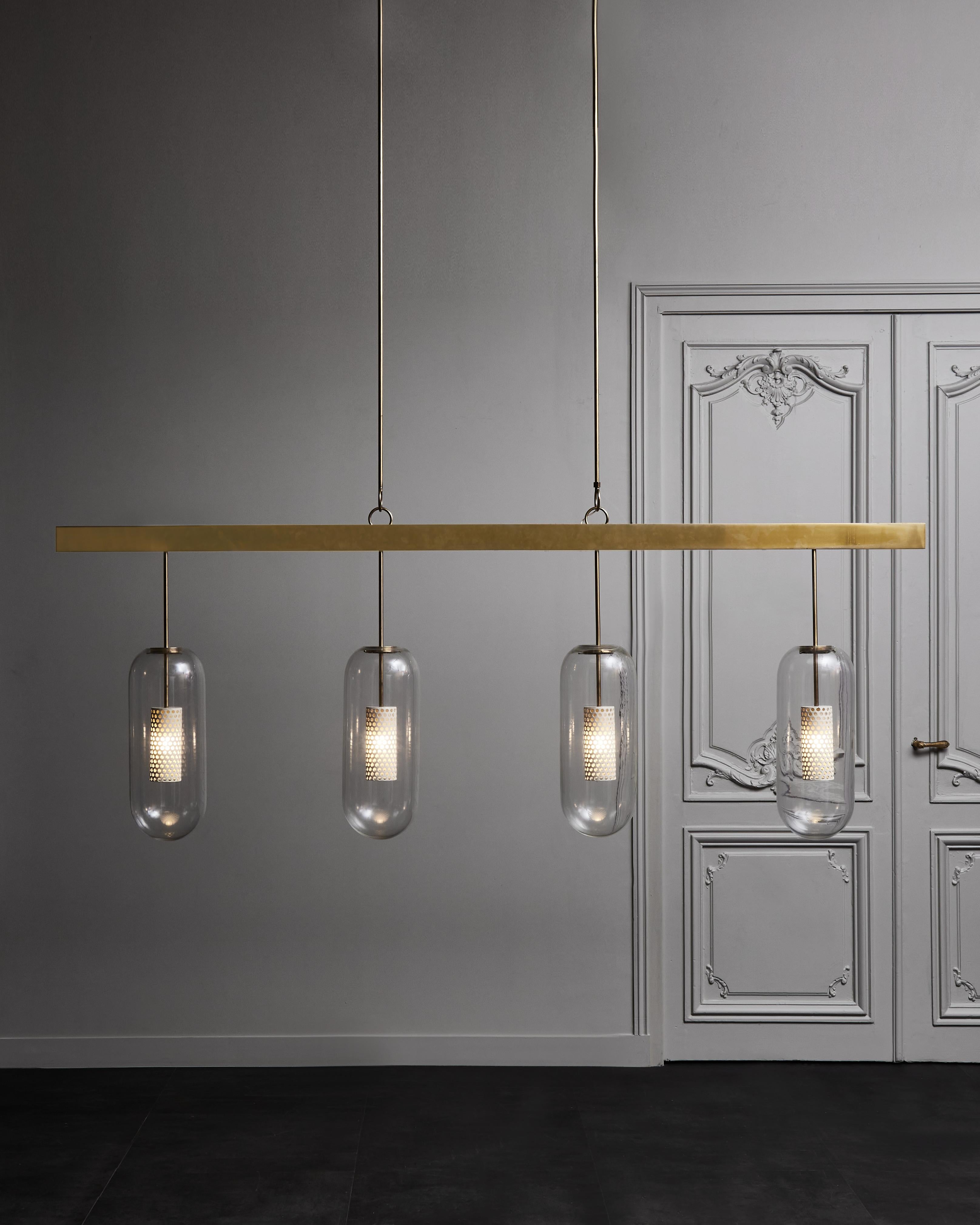 Long horizontal chandelier designed and made by Diego Mardegan.
Brass structure holding five perforated metal sconces encapsulated in glass domes.
 