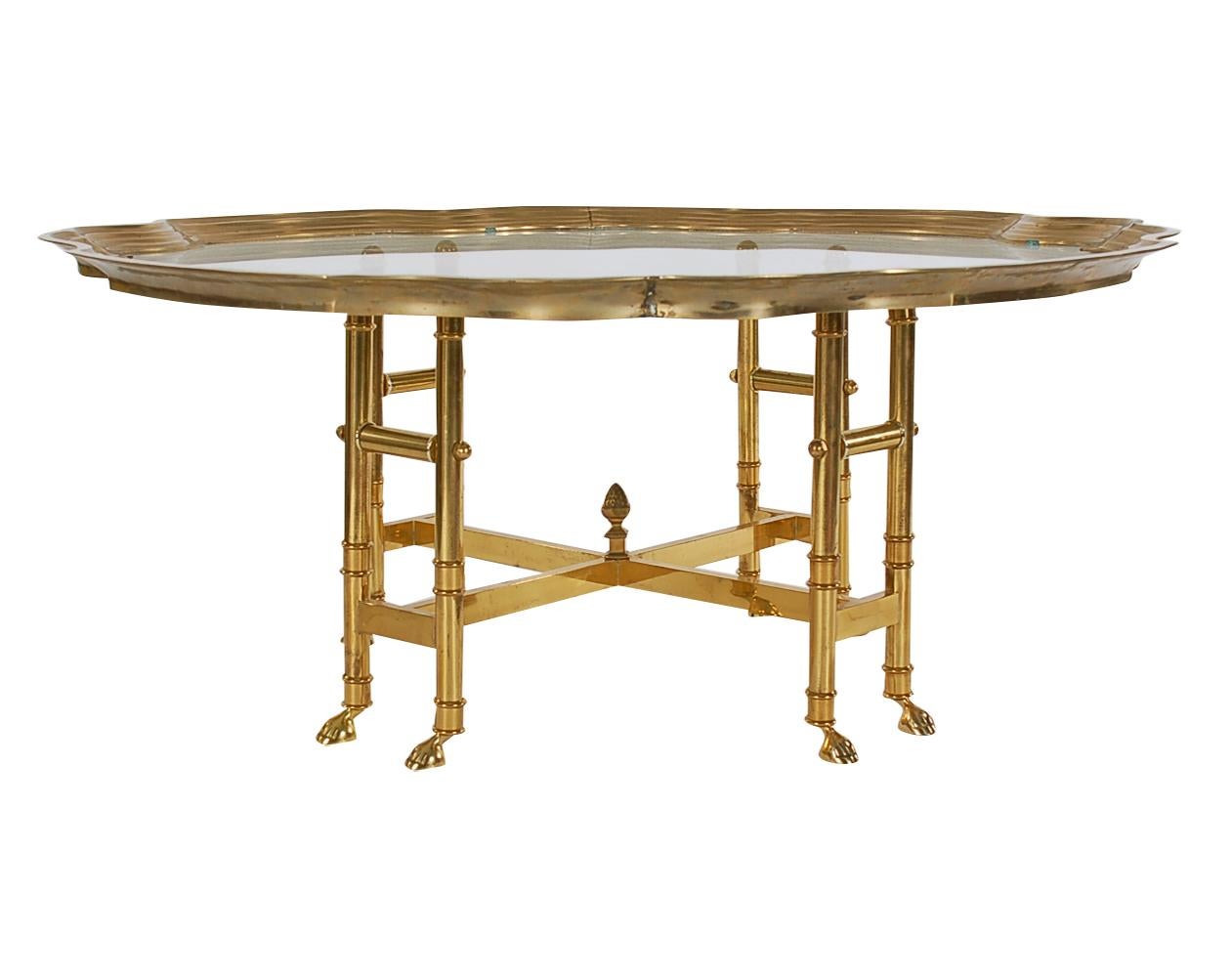 A stylish and sophisticated cocktail table probably produced by Labarge in the 1970s. A very heavy well-made piece featuring brass construction and clear inlaid glass.
   