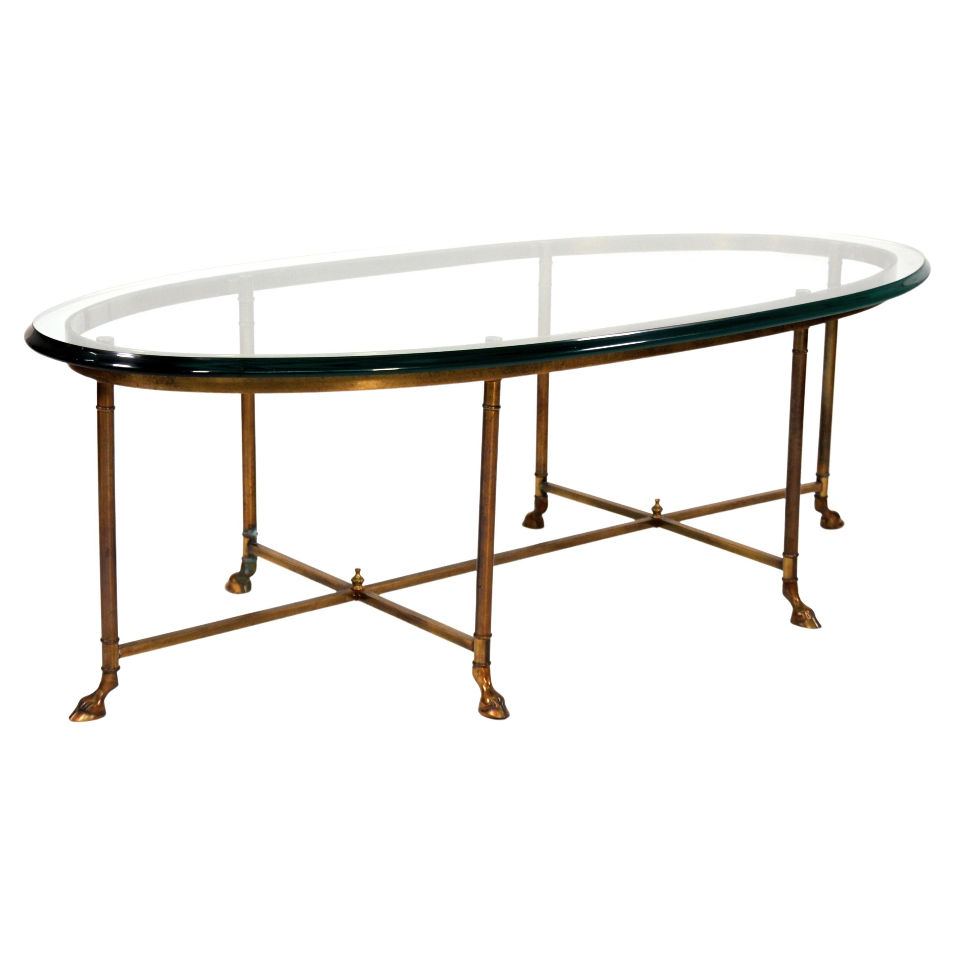 A gorgeous vintage La Barge solid brass oval cocktail table with beveled glass top. The coffee table features ram's feet and double cross stretchers with shaped finials. The brass has beautiful, rich patina. A wonderful addition to any traditional