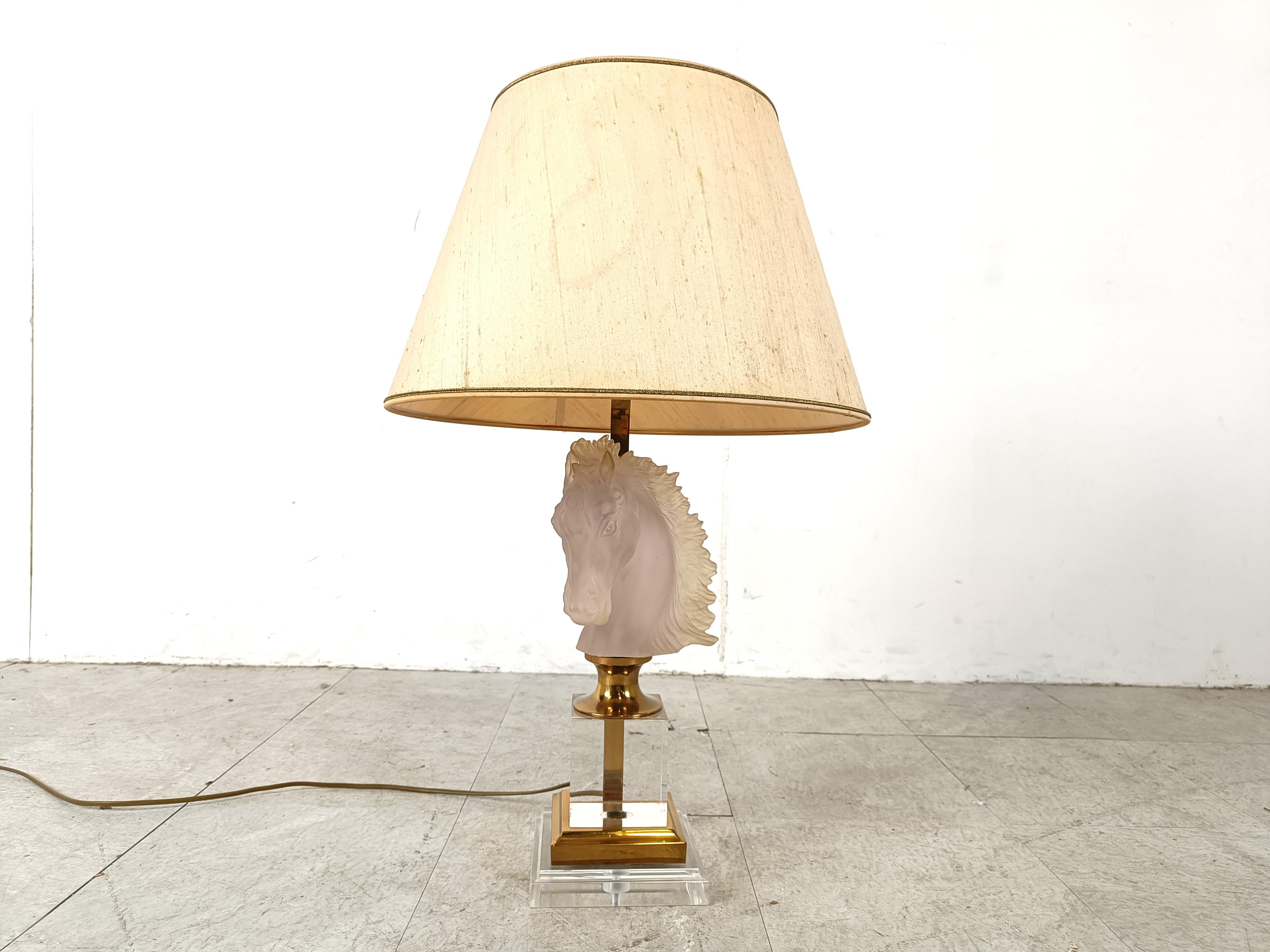 Brass horse head table lamp probably made by Maison Barbier consisting of a brass and lucite base and a glass horse head sculpture.

Stylish table lamp with a luxurious appeal.

The lamp has its original lamp shade

Rewired, tested and ready for