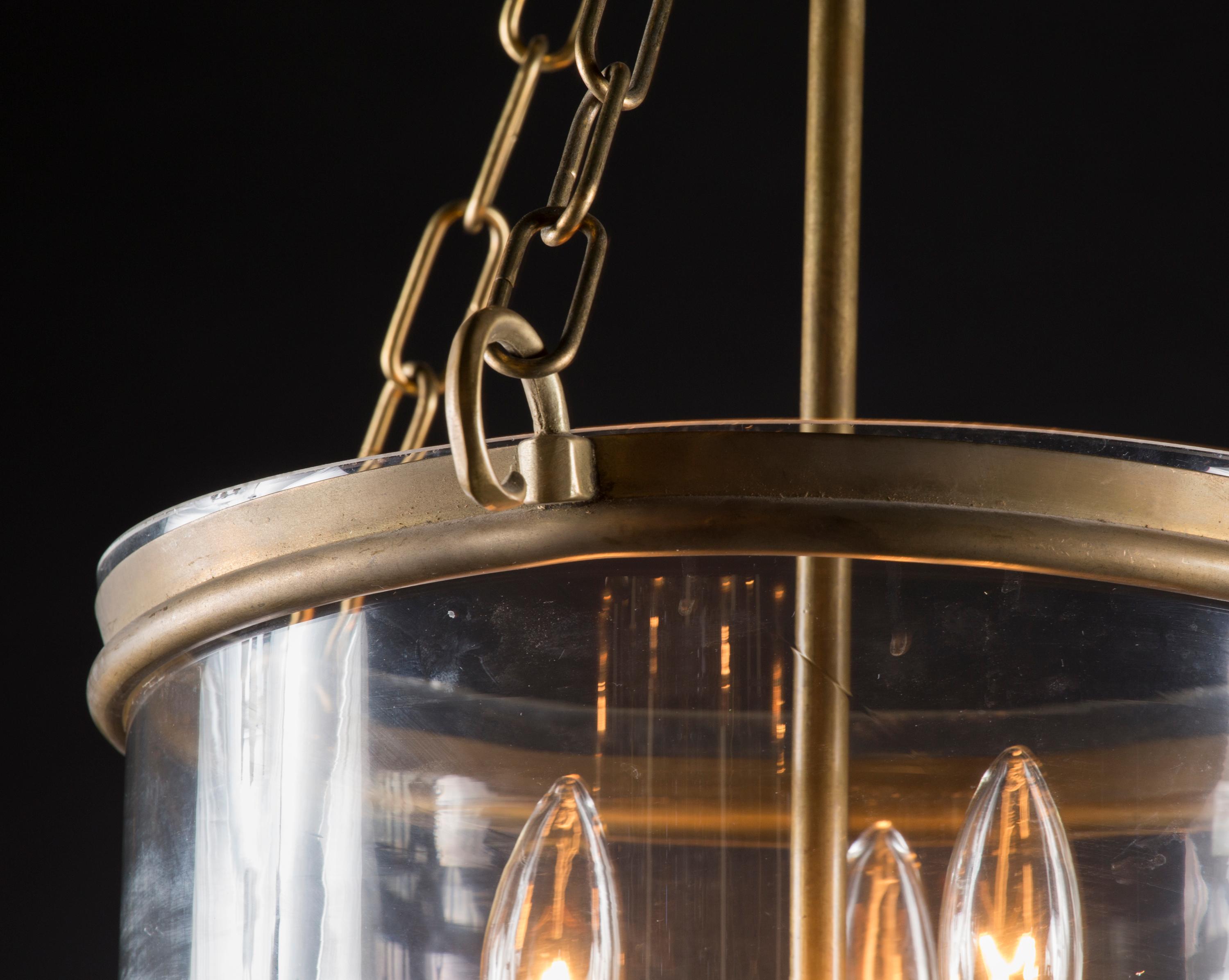 This beautiful, simple Italian hanging lantern dates back to the mid 20th Century and features both solid brass and a gorgeous bell shaped glass bowl. The three lights rest in the center of the glass, hung by the brass stem. The piece as a whole is