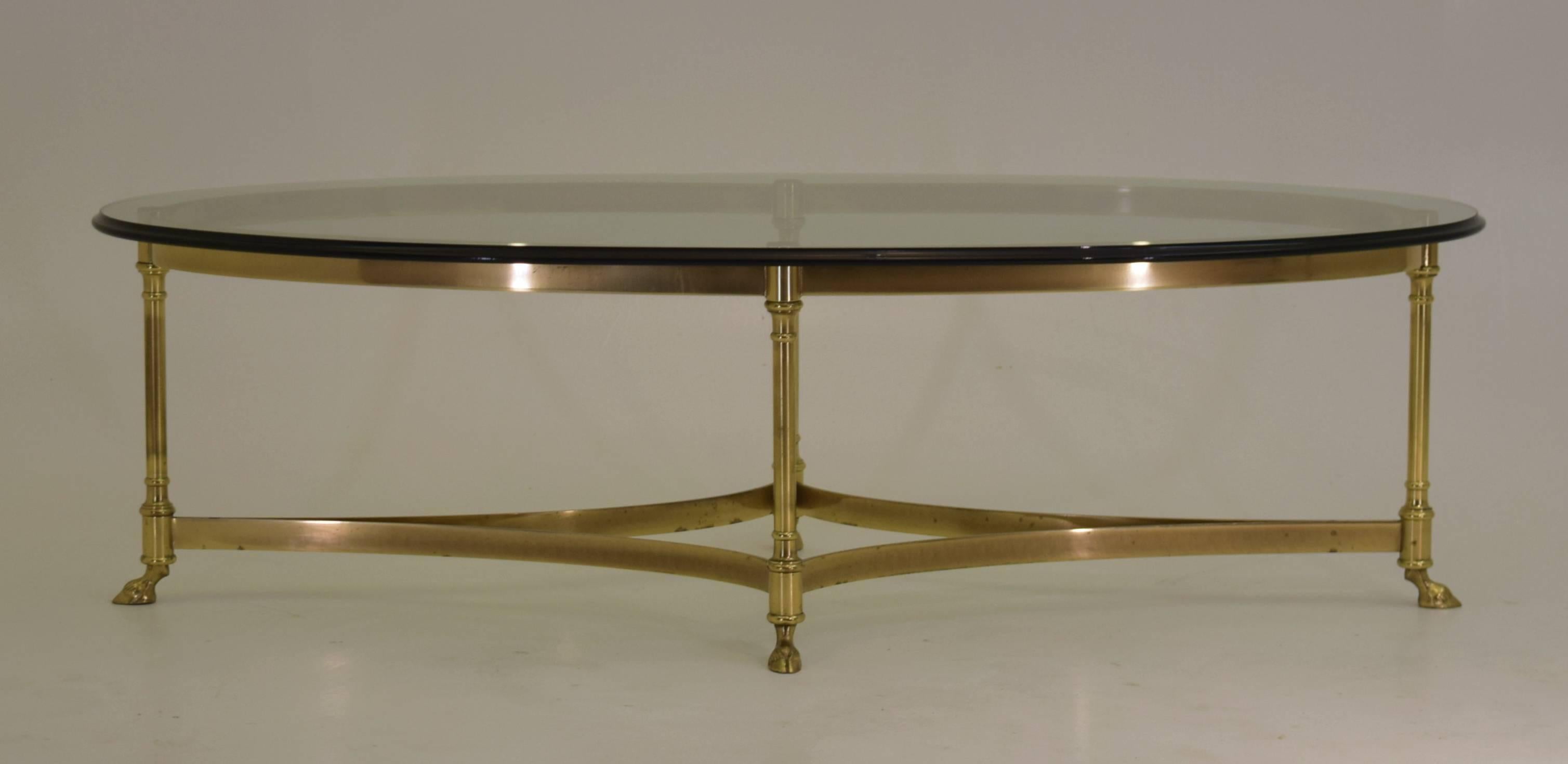 Labarge
USA, brass, glass circa 1970
Measure: 26 deep x 51.25 wide x 15 inches tall

Brass frame, with goat hoof feet - all in solid brass with bevelled thick ellipse glass table top. All original with the glass in impeccable condition.