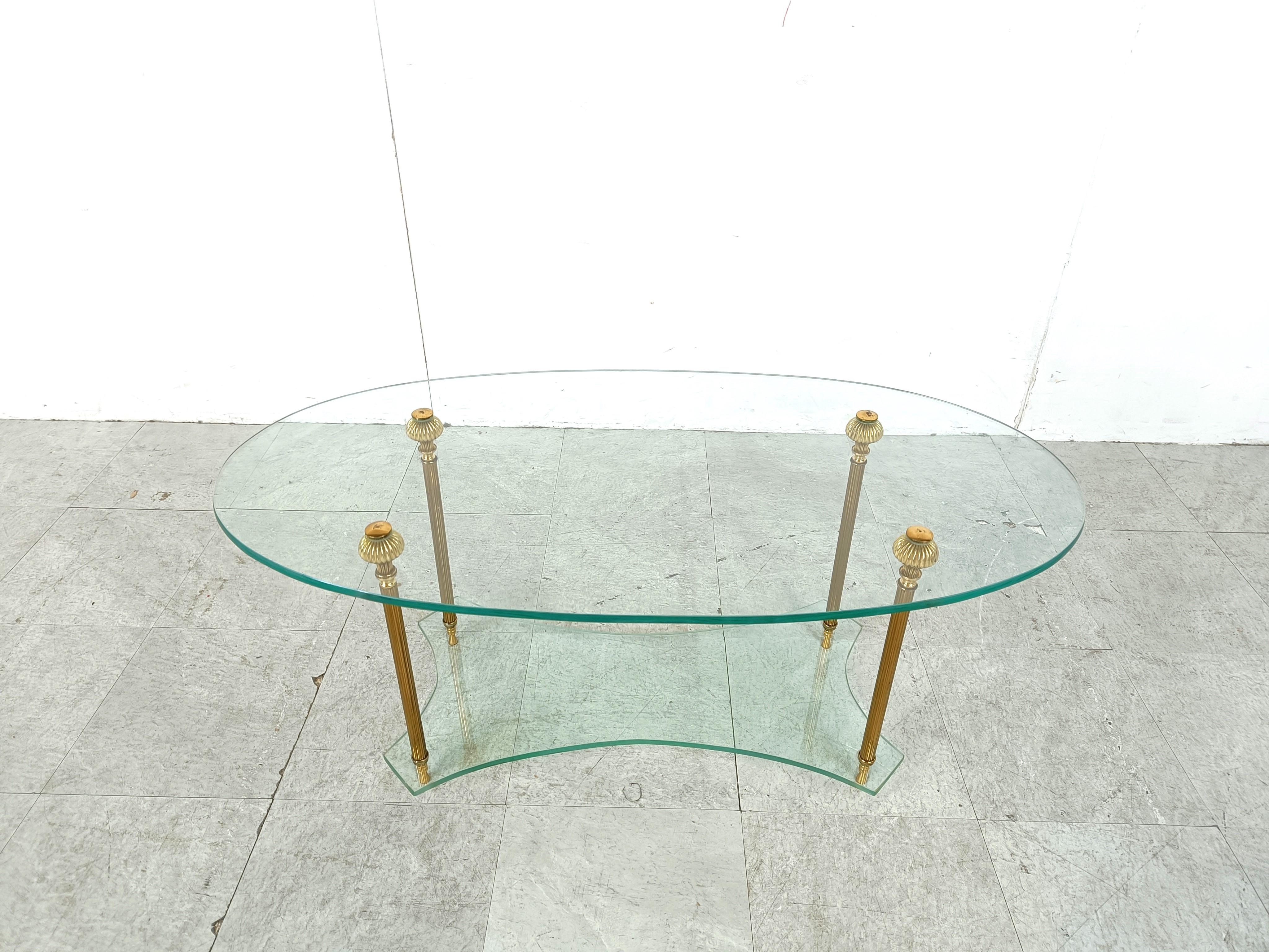 Table basse vintage en verre ovale à deux niveaux avec pieds en laiton.

Quincaillerie en laiton de style néoclassique.

Très bon état.

années 1970 - italie

Hauteur : 43cm/16.92