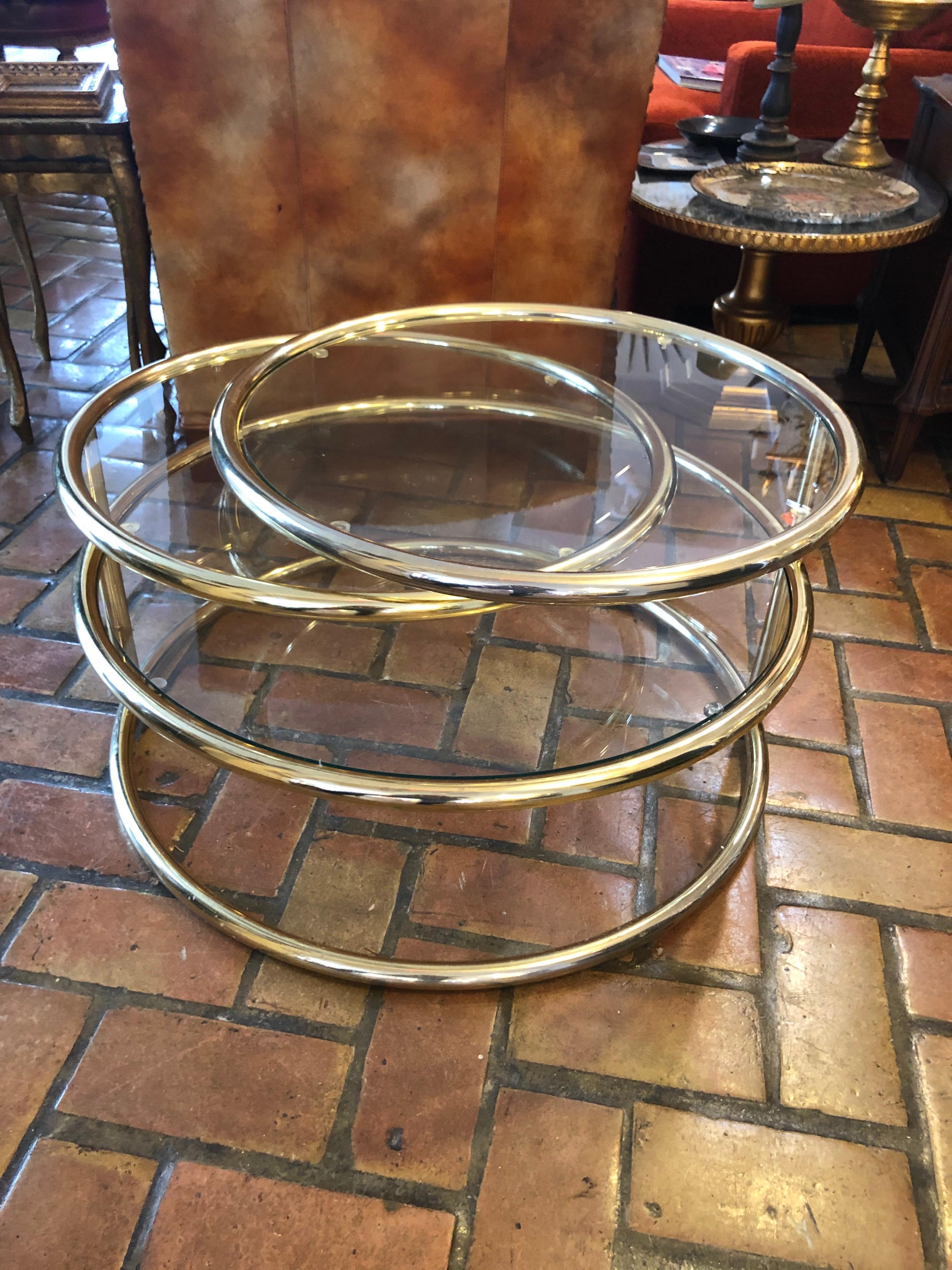 Brass and glass round three-tiered expandable table. Classic Milo Baughman styled
coffee table. Perfect for entertaining in small spaces to enlarge when needed. Bottom base has no shelf.
When fully extended width is 75