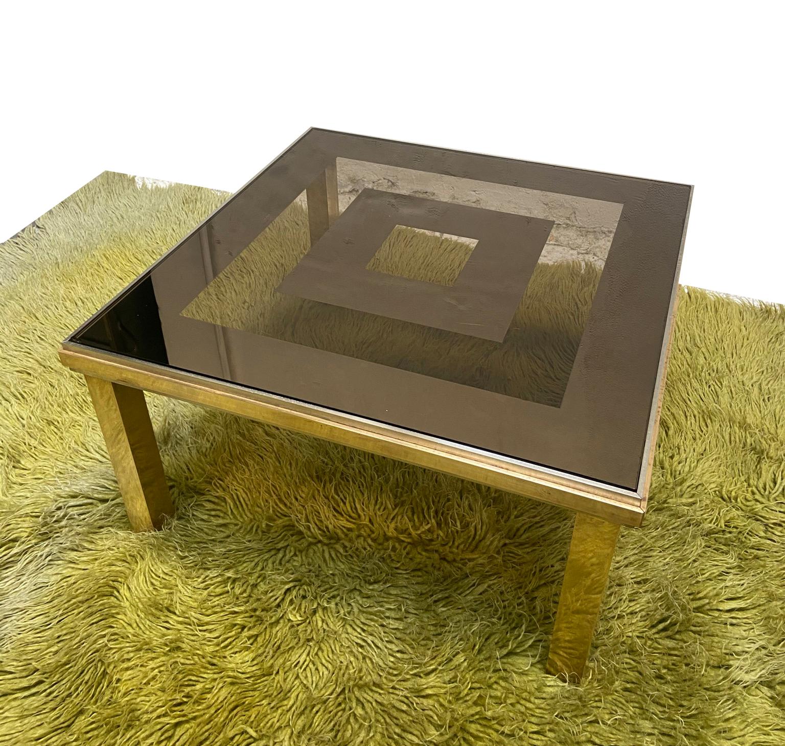 Elegant coffee table in chromed metal and brass.
Smoked and mirrored glass with geometric design adds seductive elegance to this Mid-Century piece.
Little chip in one corner of the glass.