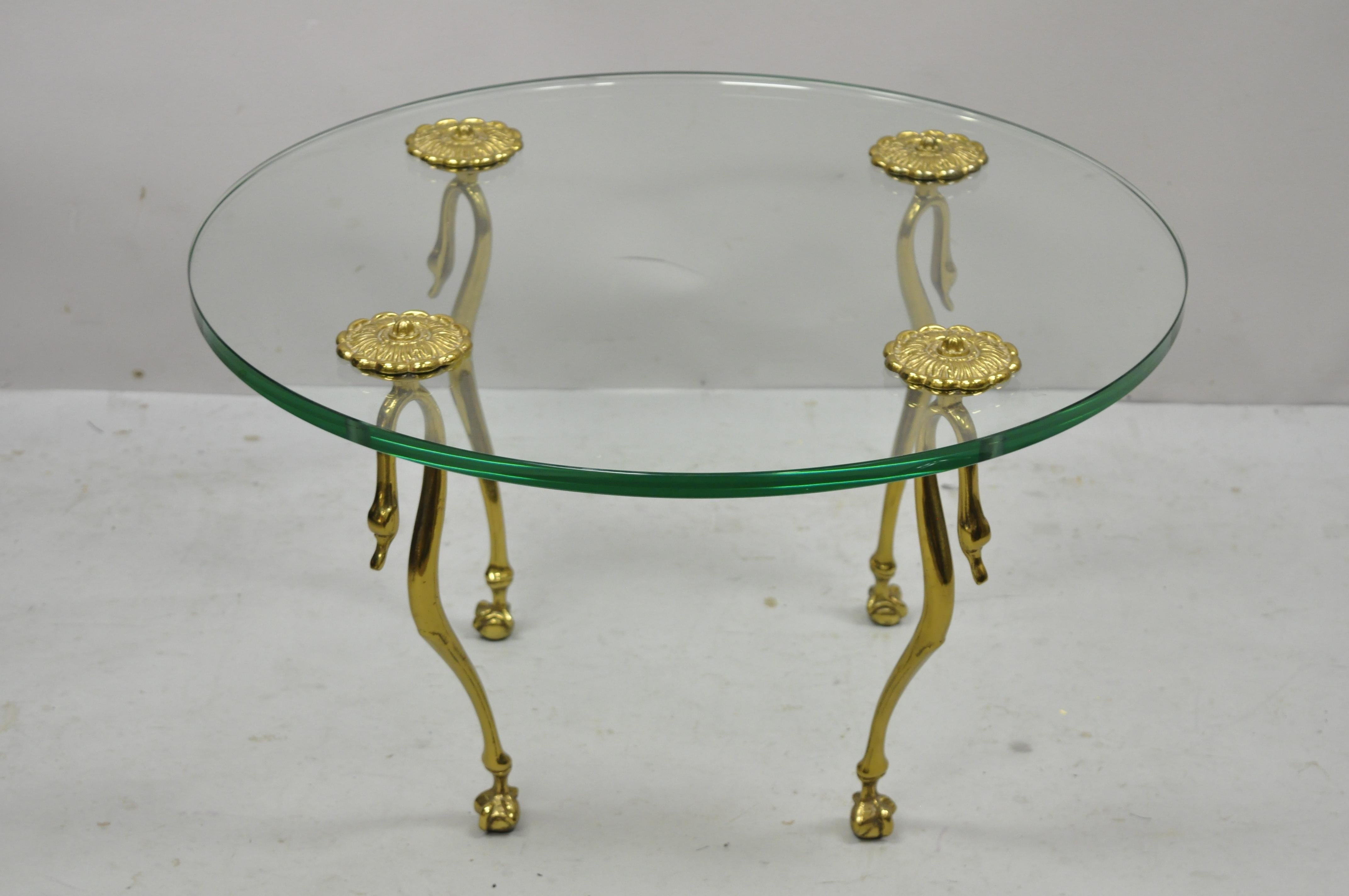 Brass and glass swan leg Regency Maison Jansen style round small coffee table. Item features thick round glass top, brass ormolu, shapely swan legs with ball and claw feet. Nice smaller size coffee table. Circa Mid to late 20th century.