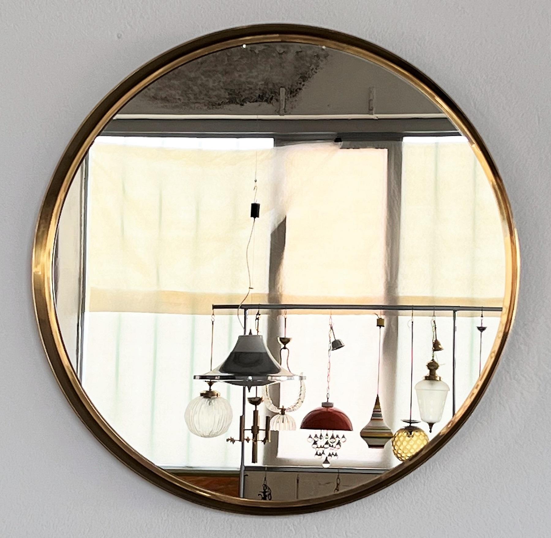 Large round luxury wall mirror made of a full brass frame with typical gold plating and crystal glass mirror.
Made by Vereinigte Werkstätten München, Germany, in the 1960s.
This big mirror is in the original condition, made of excellent