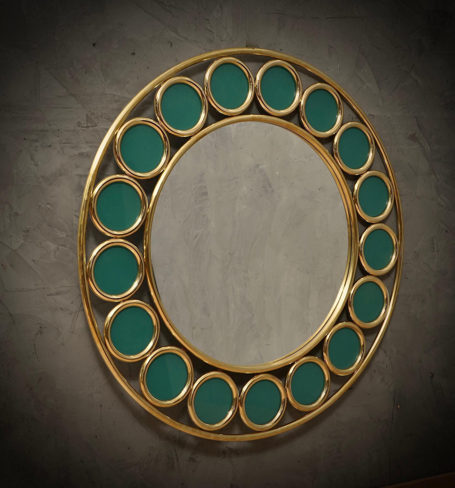A strong brass frame with a particular round design reaches the eye of the beholder, leaving him entranced; wall mirror in green colored Murano artistic glass. Original and characterful, with a beautiful shape and excellent dimensions, the wall