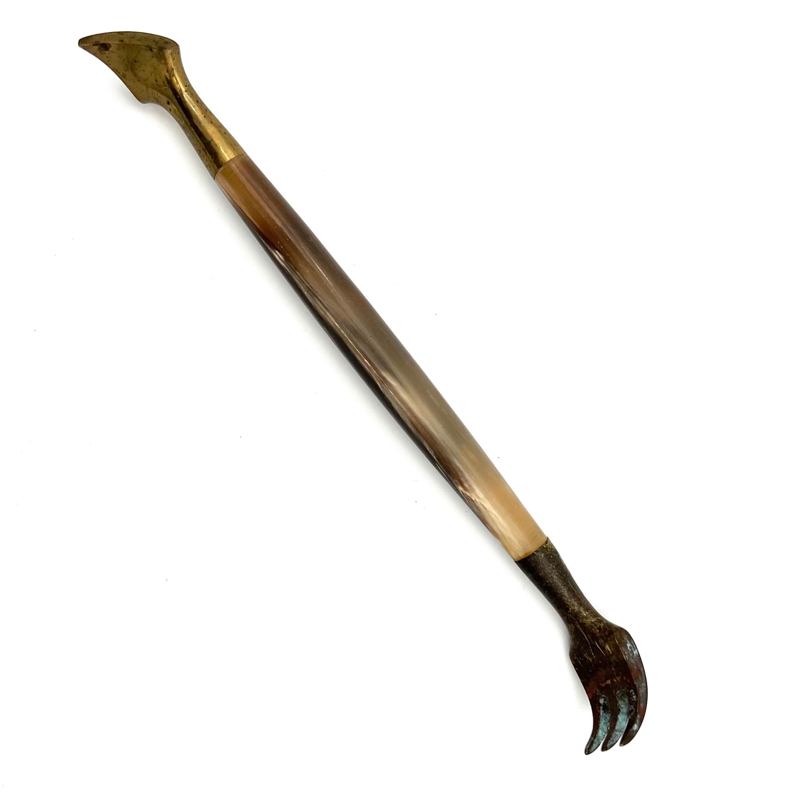 Brass and horn cactus gardening tool by Auböck, designed in the 1950s.
The end of the tool is made of solid brass on both sides, the handle in the middle is made of horn.

Oxidation/ brassing on the fork.
Total length: 21 cm.