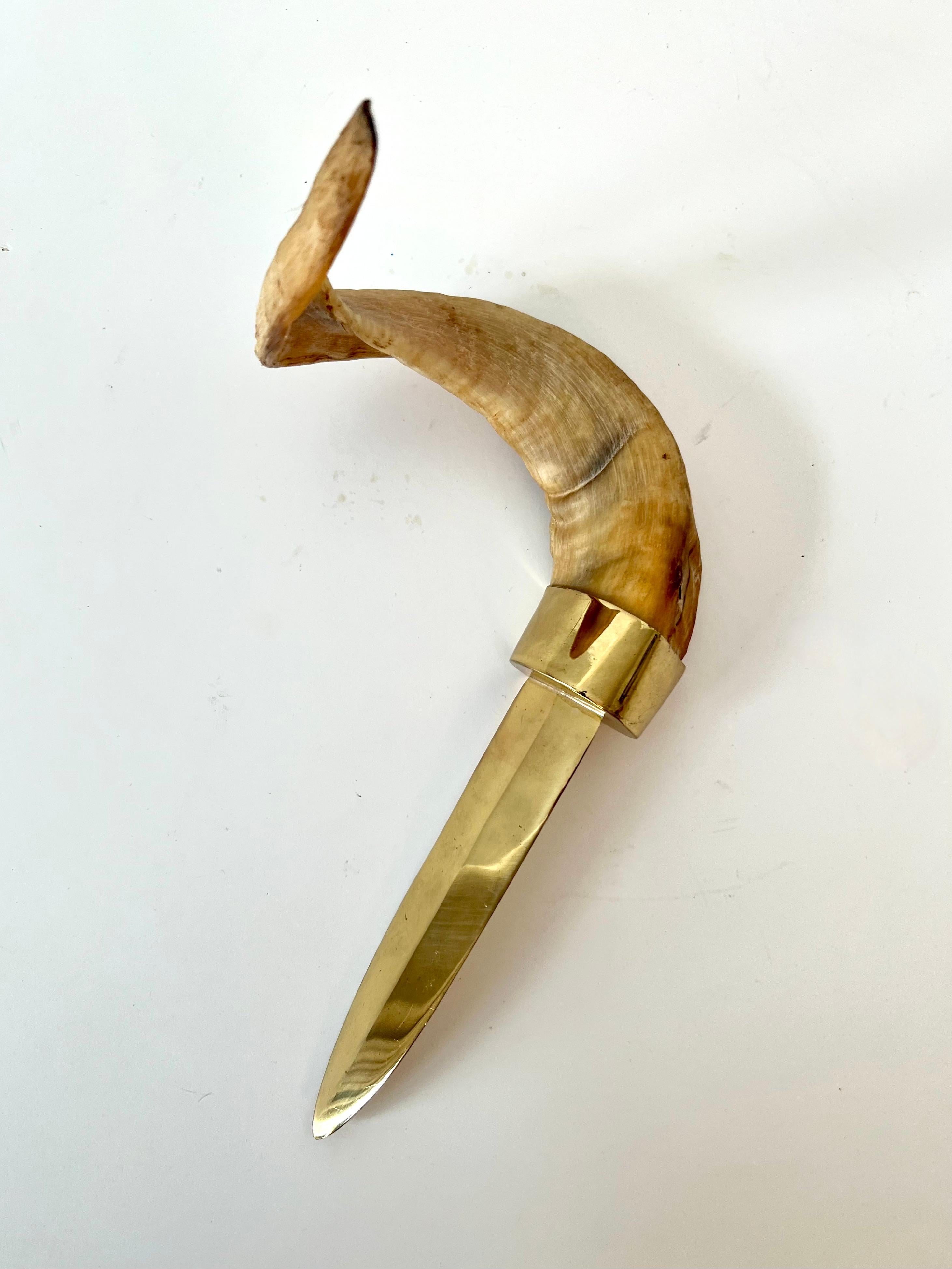 a stunning and large letter opener in brass with a horn handle.  The piece is impressive and shines bright.  A compliment to many settings - a funcktional piece of art on any desk or work station.

The piece would be a great graduation gift, wedding