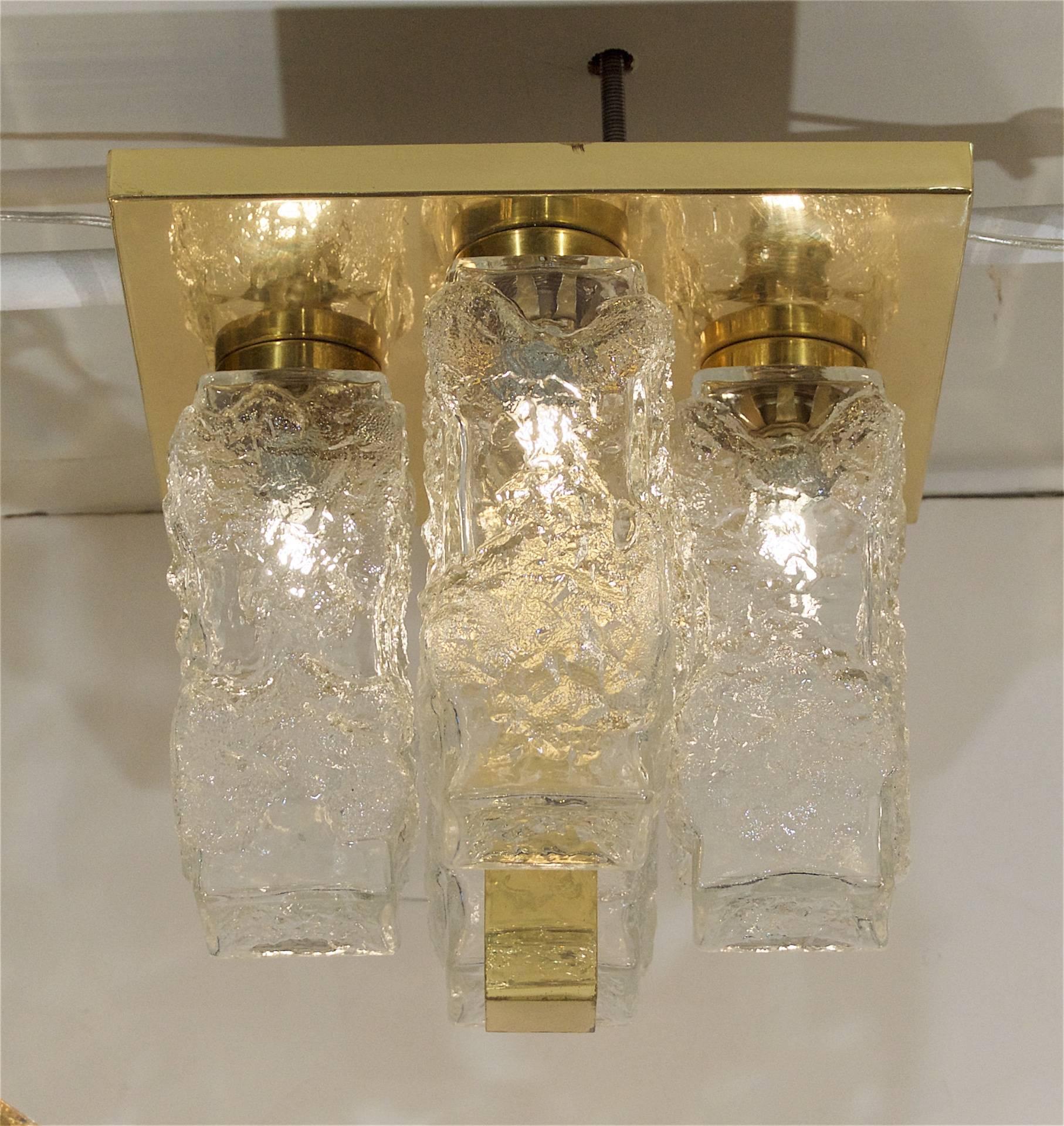 Excellent and dramatic flush mounts by Hillebrand, the brass backplate with central pillar anchoring four ice block glass covers.

Takes 4 E-14 base bulbs up to 40 watts per bulb, new wiring.

Price listed is per flush mount. (5 available).