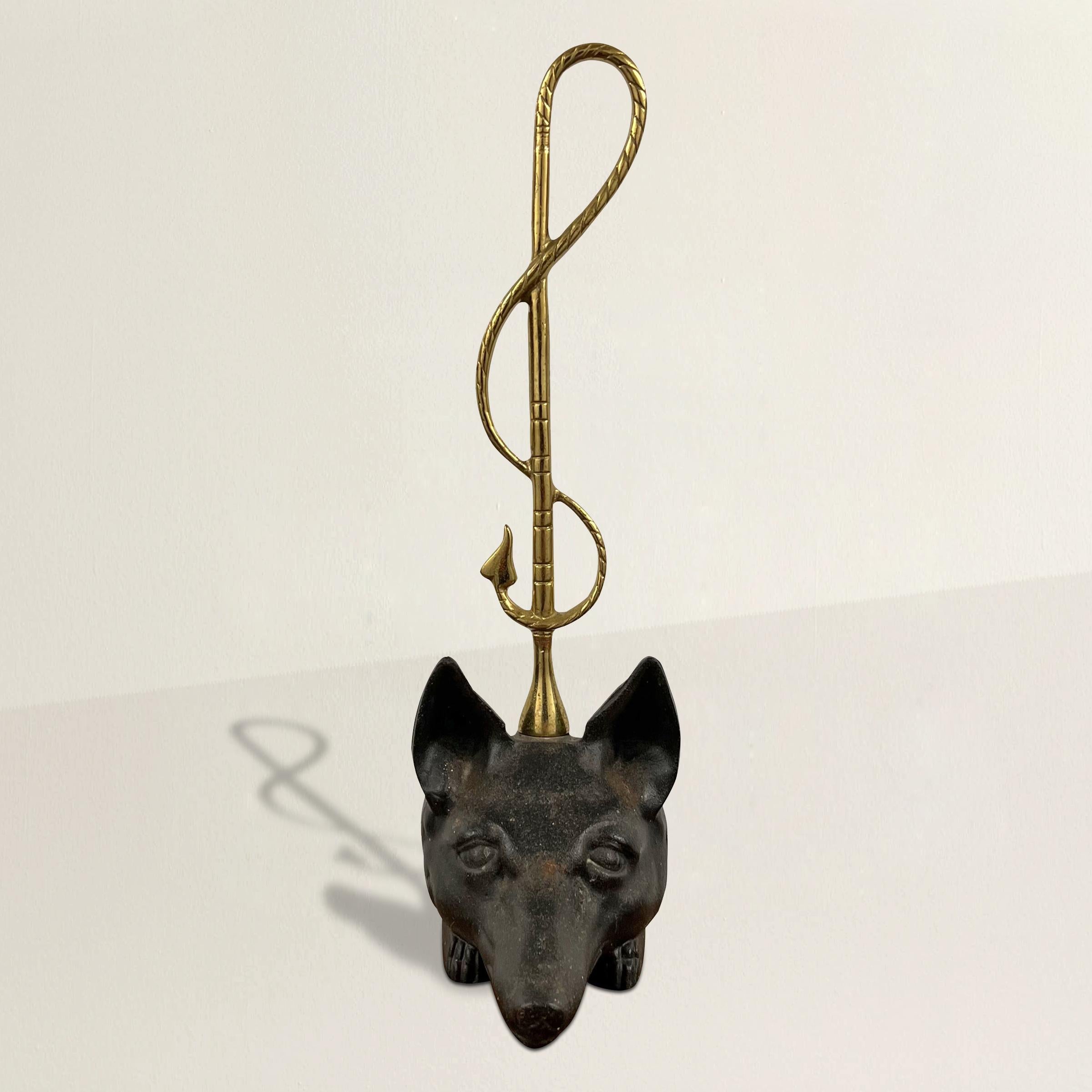 A mid-20th century American cast brass and iron fox doorstop with an iron fox head and paws and a cast brass horsewhip handle.  