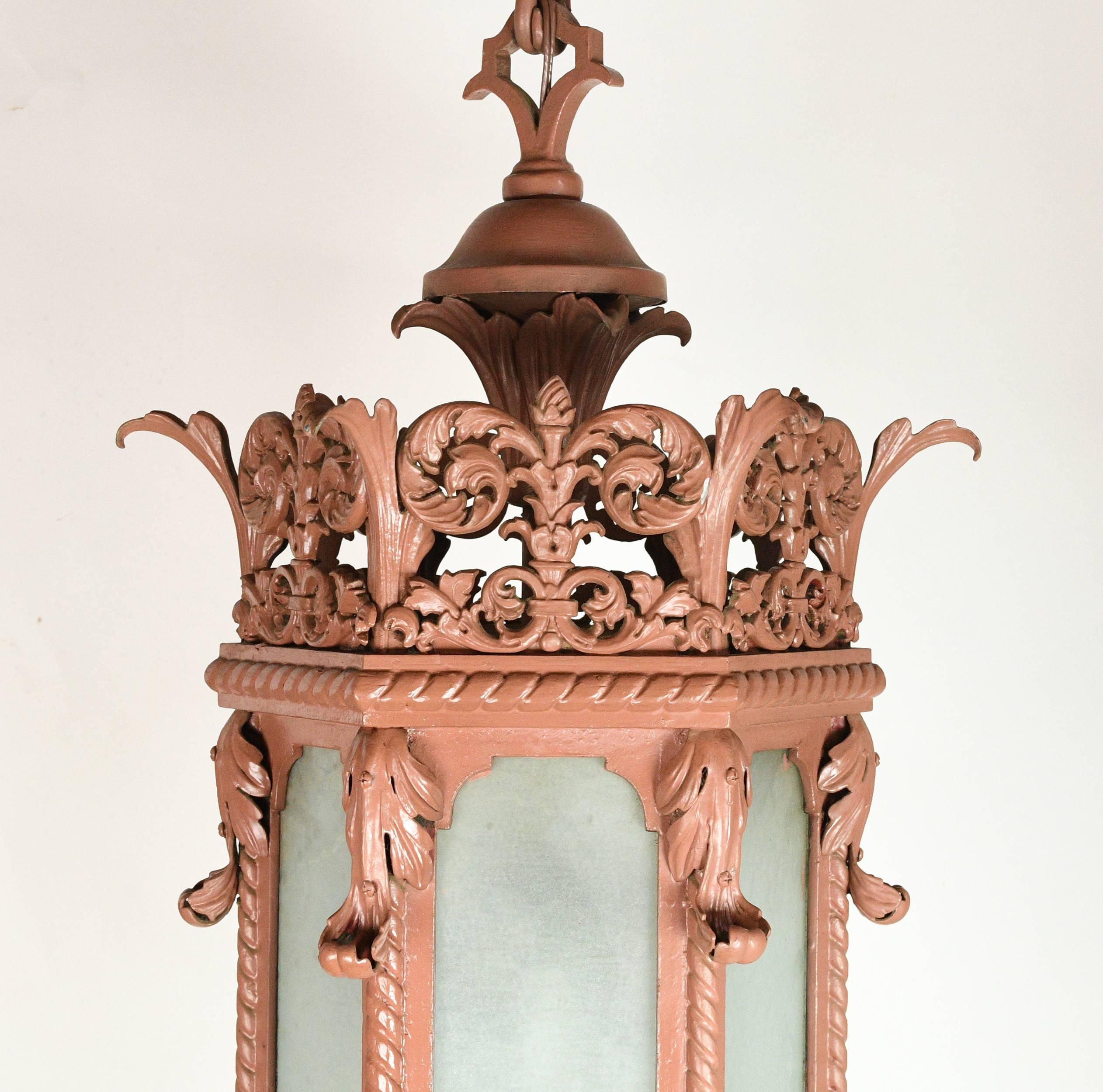 This stunning brass and iron theater pendant was originally housed at Northrop Auditorium on Minneapolis' University of Minnesota campus. Textured blue-green glass compliments the blush red finish of the fixture, while floral filigree details add