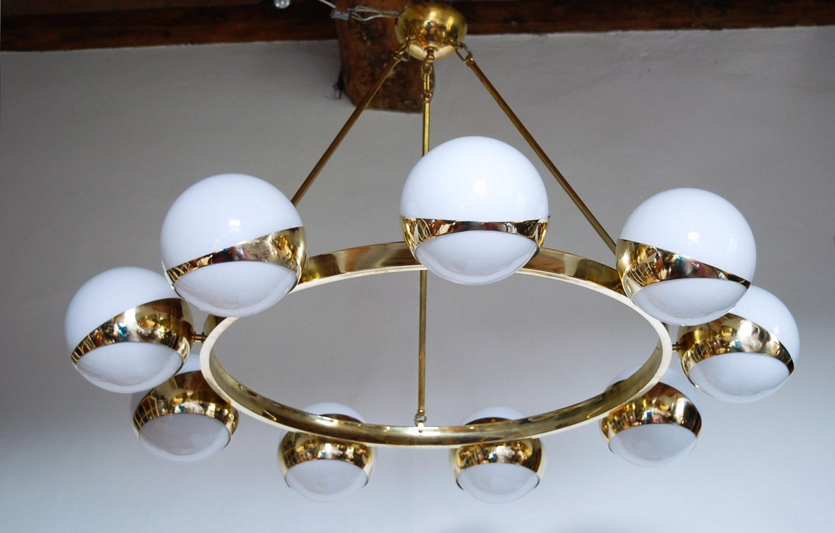 Charming, a statement chandelier.  Uses solid brass frame with a circular frame and 9 short arms with asymmetric ring holders and Venetian lattimo glass.

The perfect combination and the high light output makes it a perfect dining room chandelier.