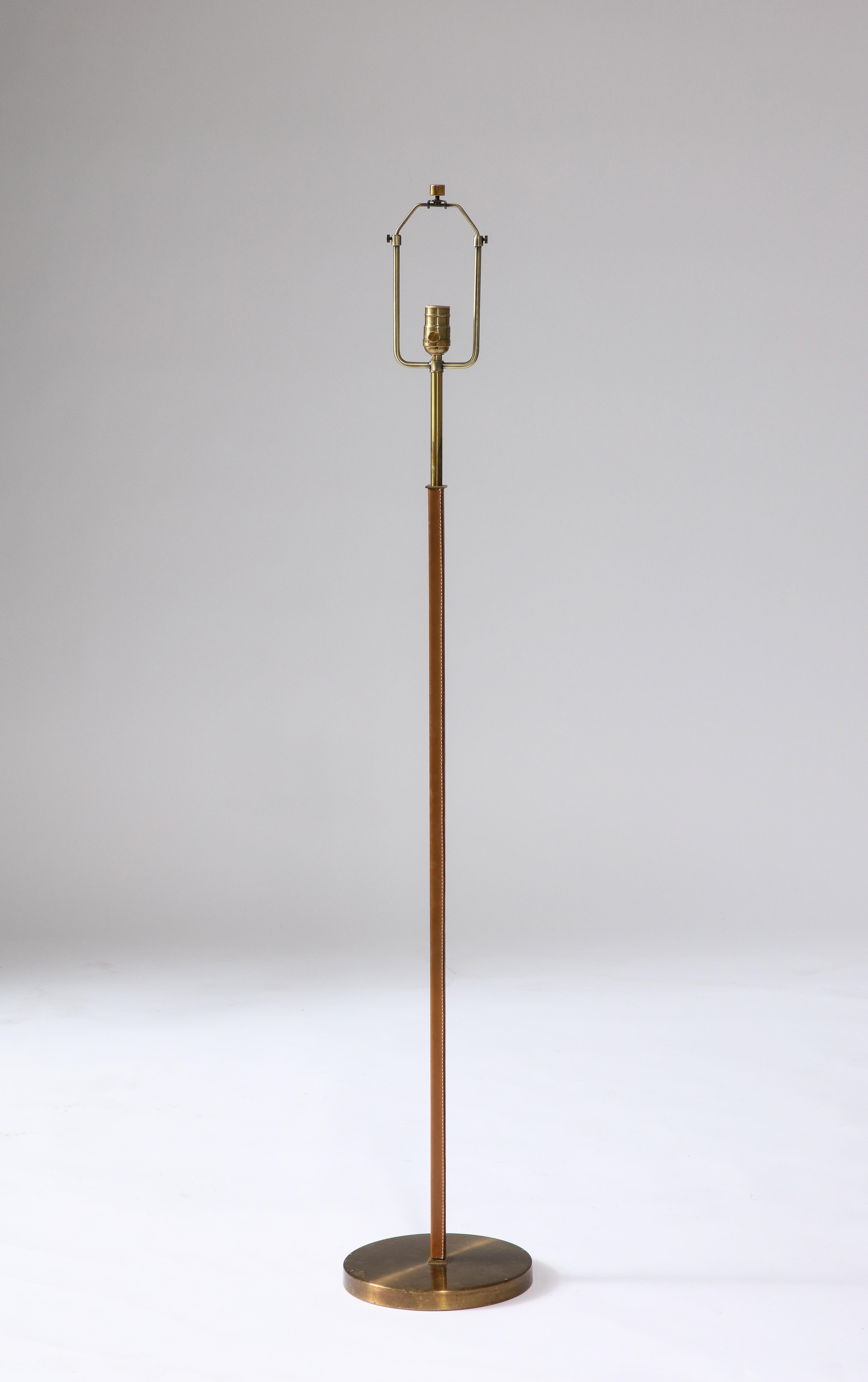 Patinaed brass and beautifully aged leather floor lamp designed and produced by Falkenbergs Belysning in Sweden.