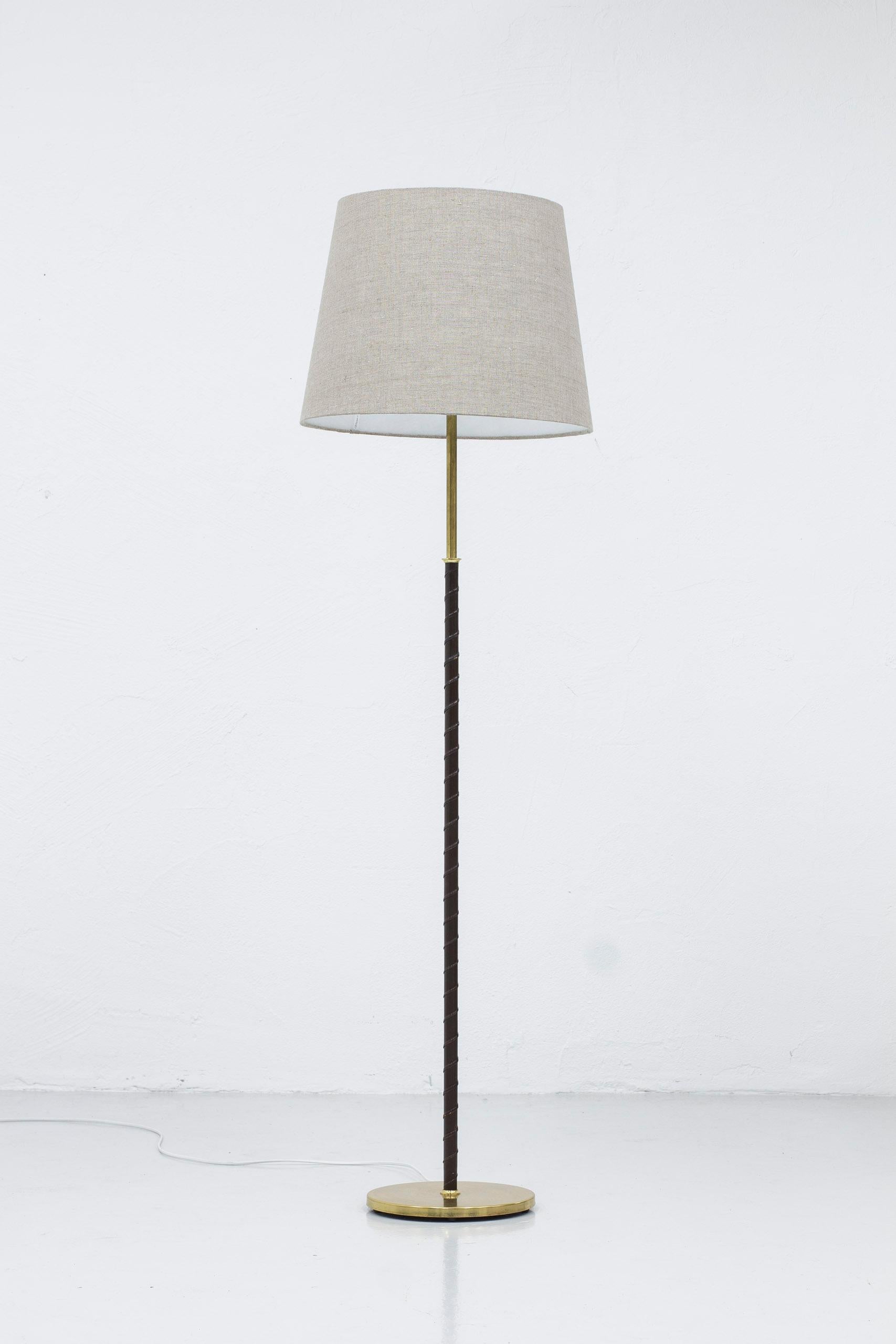 Floor lamp produced in Sweden by Möller Armaturer. Made during the 1950s. Brass base and stem with original dark brown leather. New linen lamp shade in grey included in purchase. Light switch on the lamp holder in working order. Good vintage