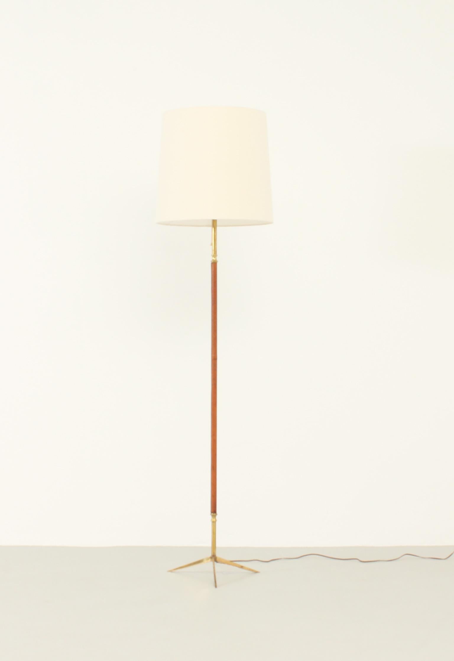 Spanish floor lamp from 1950's. Base and stem in brass covered with leather with new fabric shade.