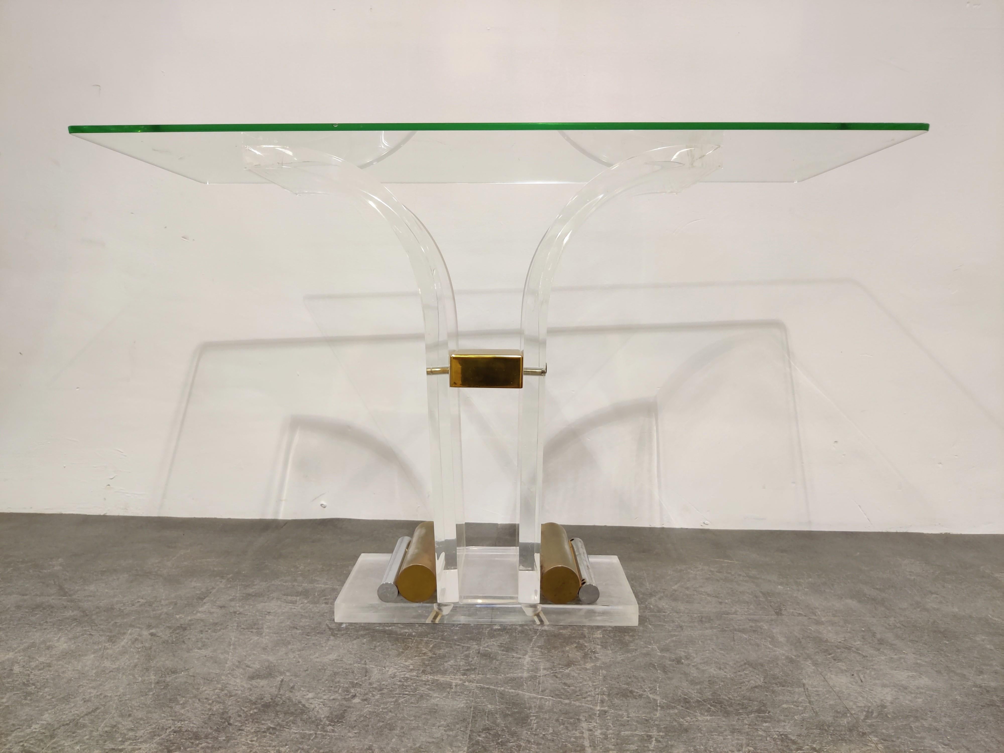 Elegant console table with a Lucite and brass pedestal base and a clear glass top.

The glass top is only an example, we can order custom glass to your wishes.

Attributed to Charles Hollis Jones and manufactured by Belgochrom

Scratches on