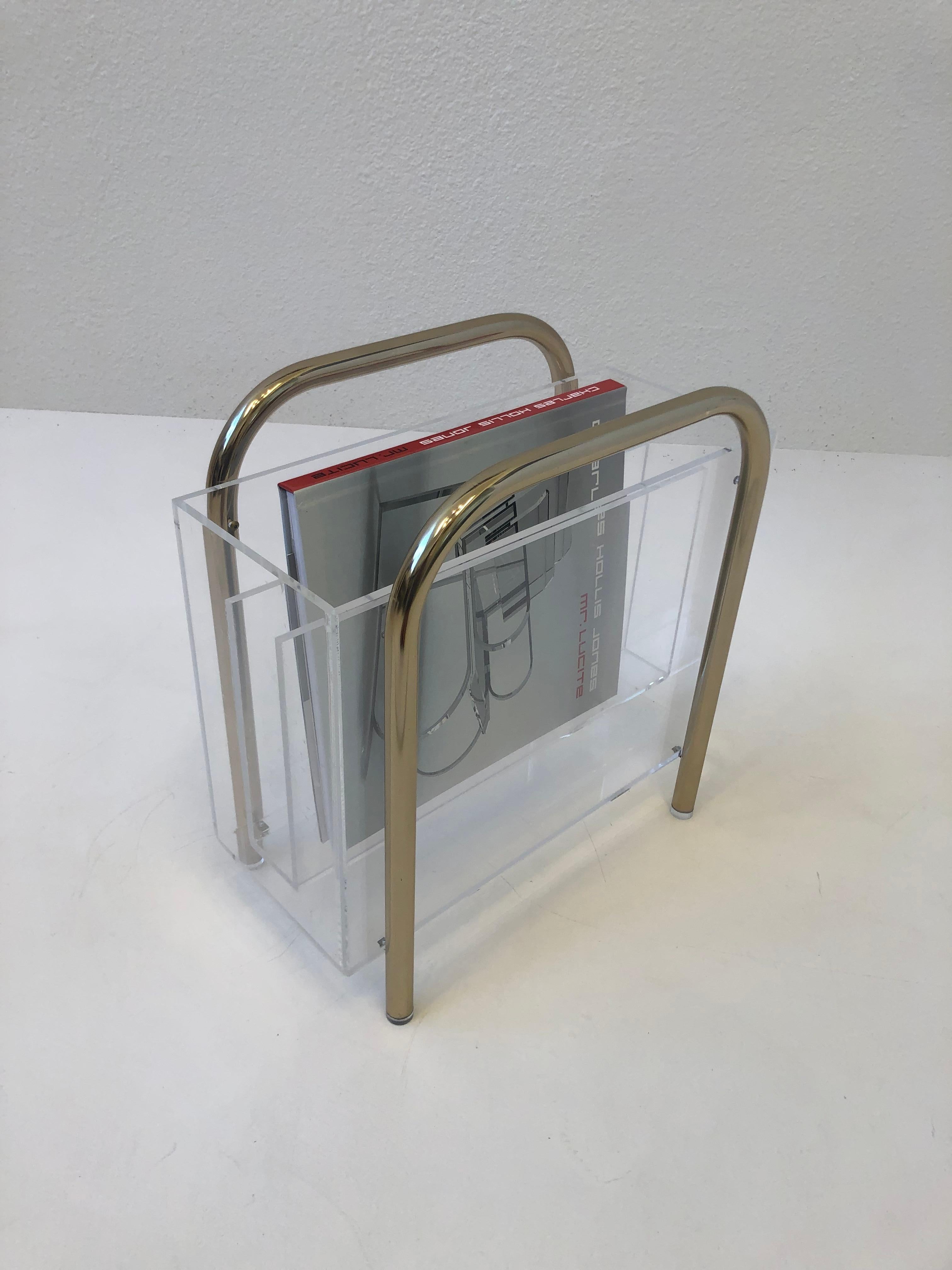 1970’s Magazine holder by renowned American designer Charles Hollis Jone. 
Constructed of clear lucite and polish brass. We also have a chrome one in a different listing. 
It’s in original condition, it shows minor wear consistent with age and