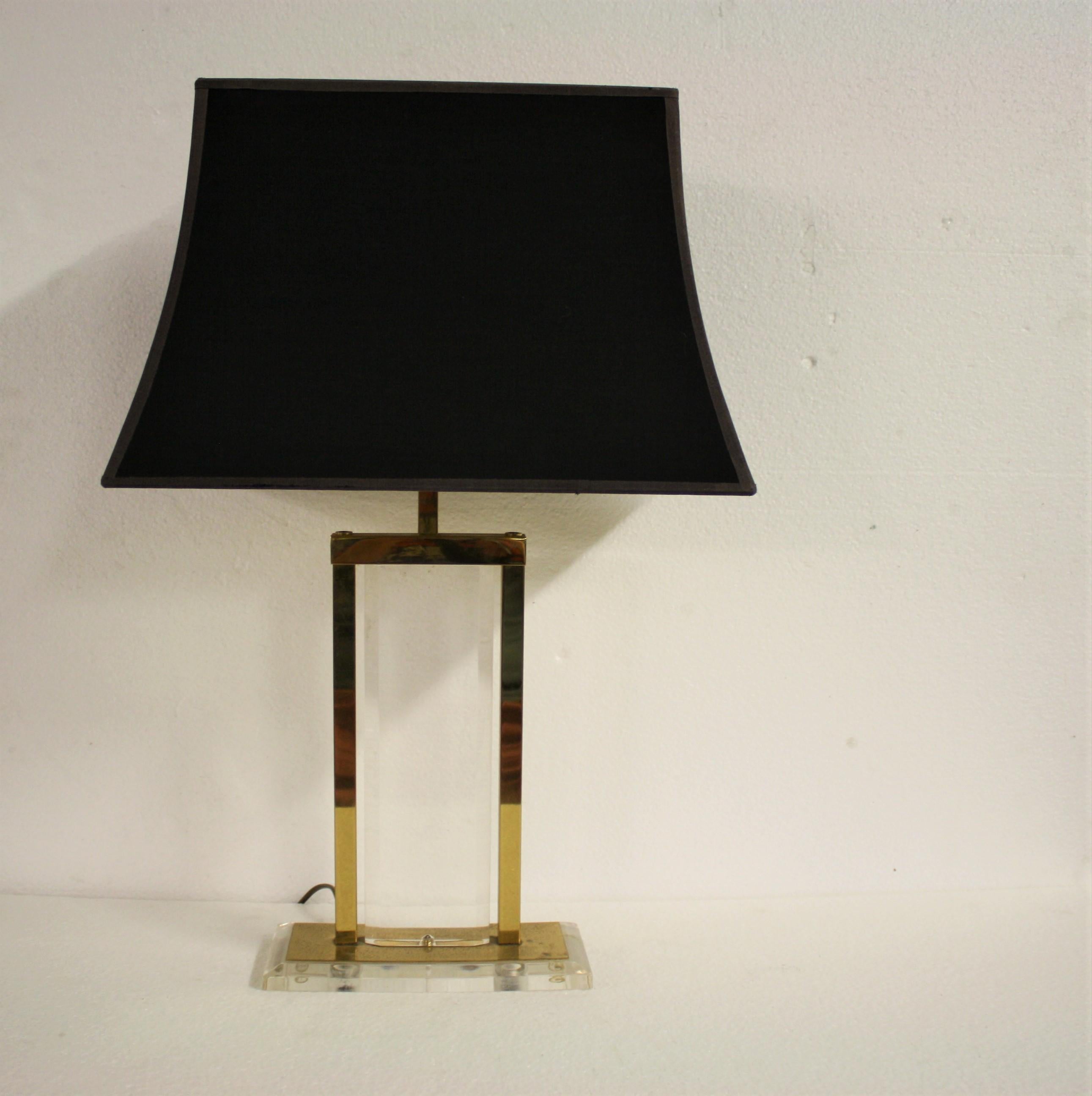 Brass and Lucite table lamp with a black fabric shade. 

The lampshade has a charming golden finish on the inside and emits a warm light.

The Lucite on the lamp is in good condition and the brass is slightly patinated, which makes the item look