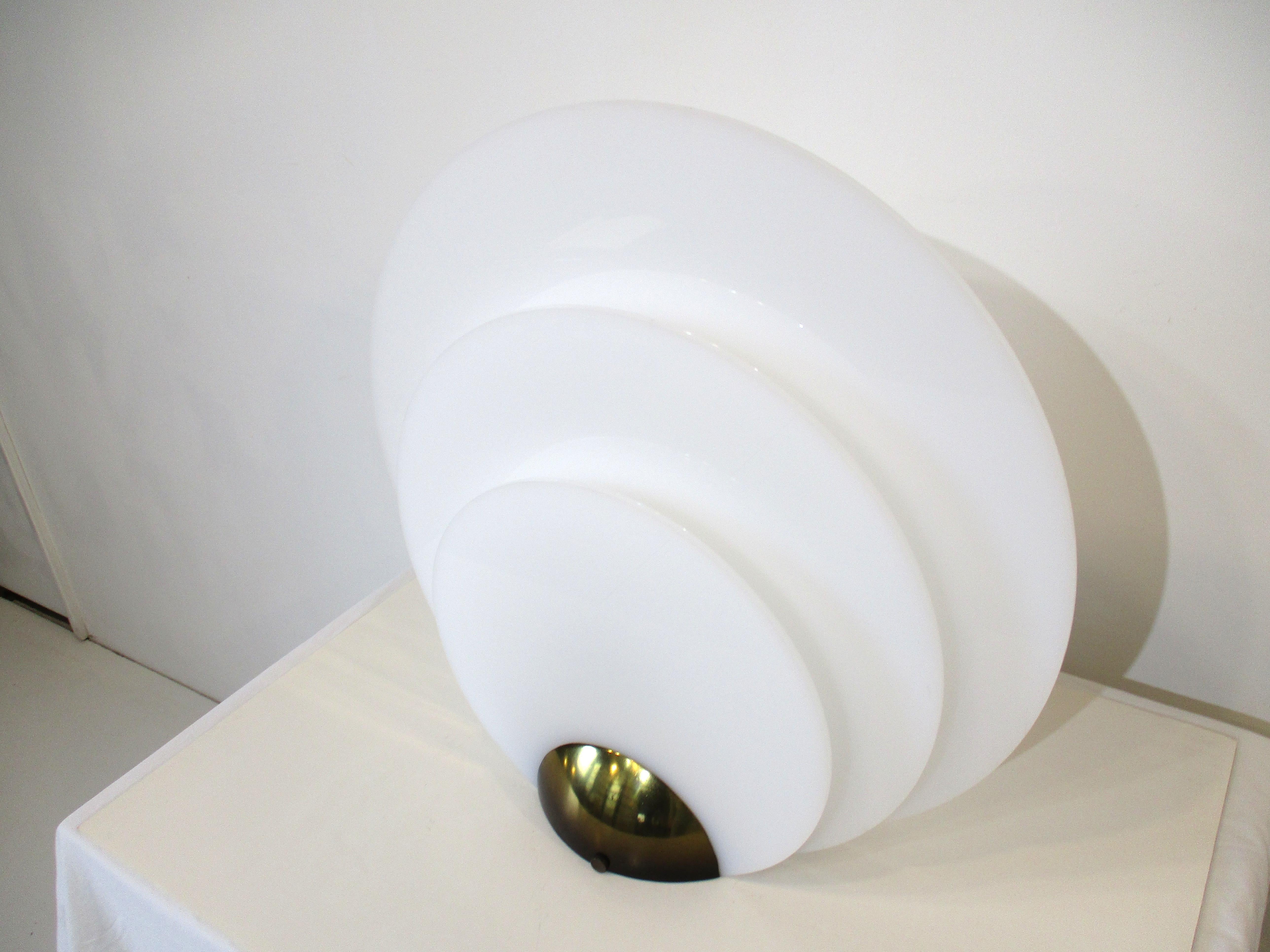 Eine gut gemachte Tischlampe in der Art von Roger Rougier mit fünf abgestuften runden weißen Lucite-Scheiben als Entschärfungsschirme. Jeder rutscht in Schlitze, die sie sehr gut in einem schweren Guss-Messing-Basis mit der Leuchte mit Glühbirne in