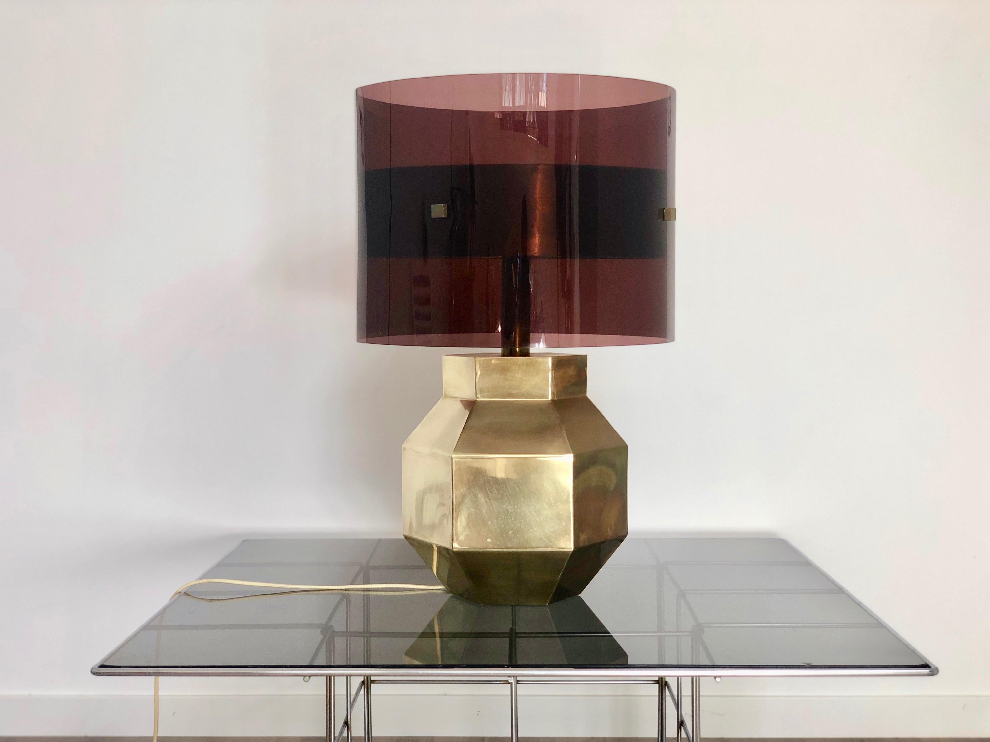 Table lamp featuring a brass base in the shape of a hexagonal solid and a lampshade in Lucite. Two lights can be turn on. Italian piece, circa 1970.
