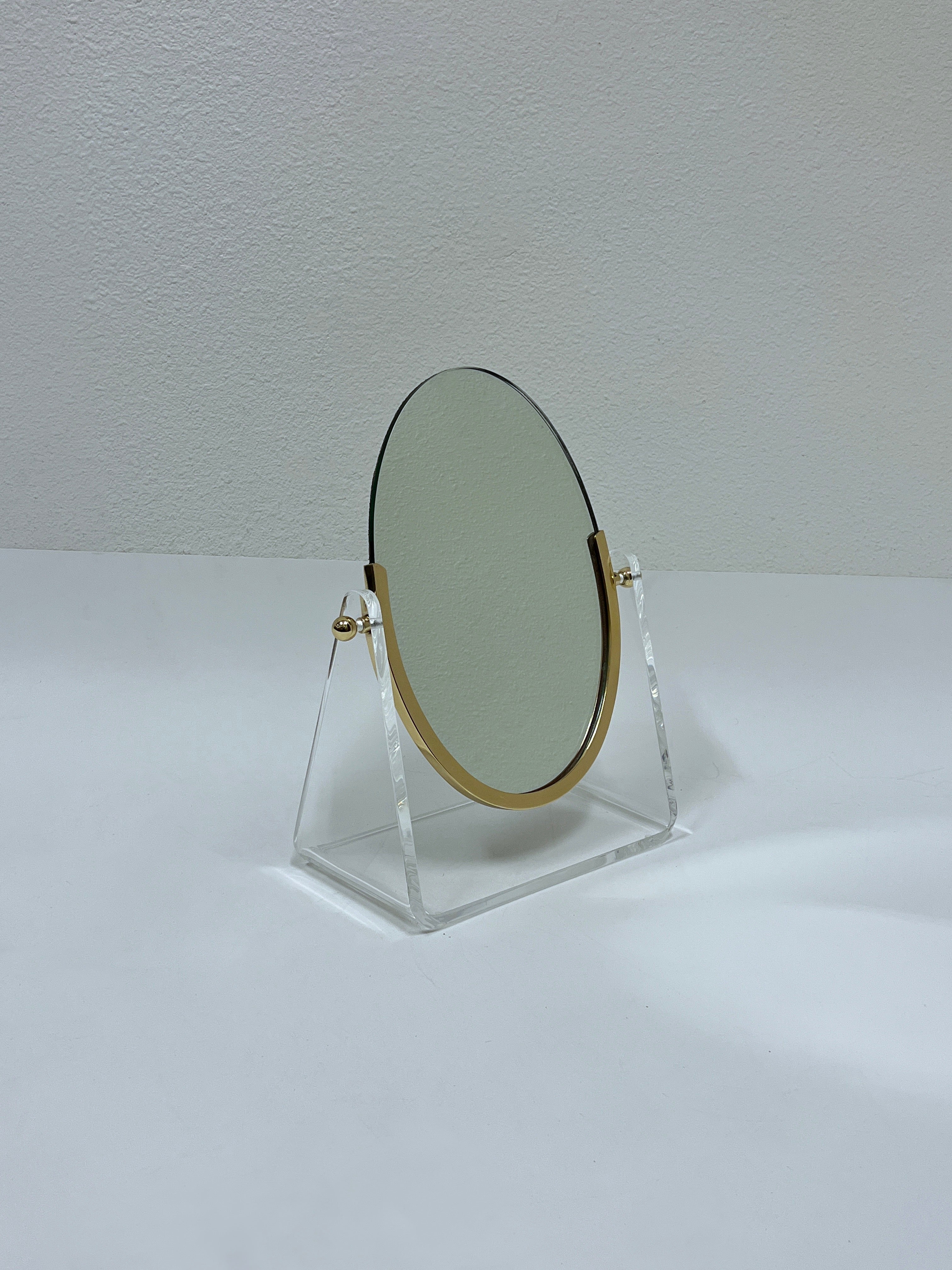 Glamorous 1970’s Lucite and polish brass vanity mirror by American renowned designer Charles Hollis Jones. 

Measurements: 13”wide, 6.25” deep and 16” high.