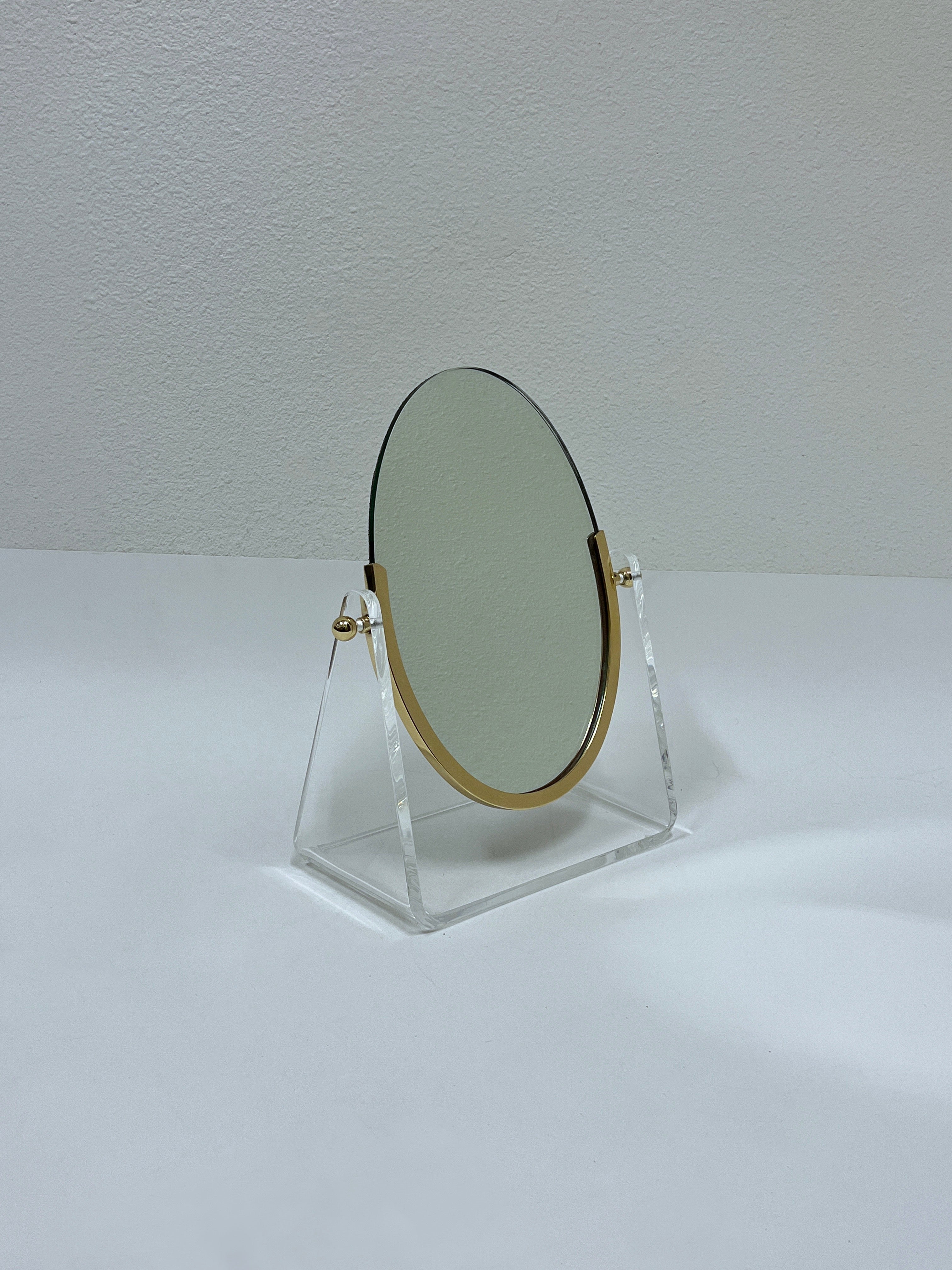 Miroir de courtoisie glamour des années 1970, en Lucite et laiton poli, du célèbre designer américain Charles Hollis Jones. 

Mesures : 13