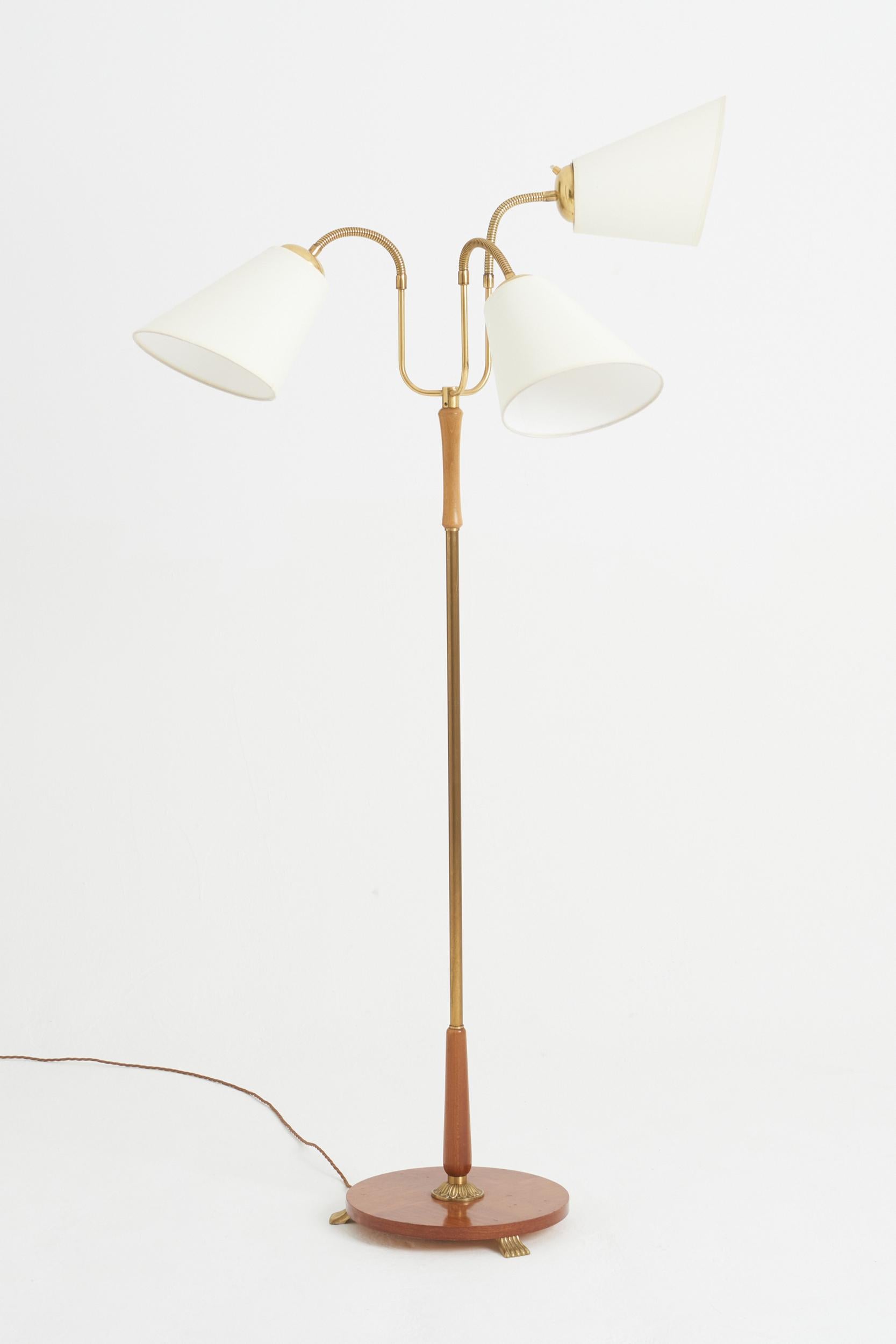 A brass and mahogany veneered three-armed floor lamp.
Sweden, 1940s
180 cm high by 70 cm wide by 70 cm depth