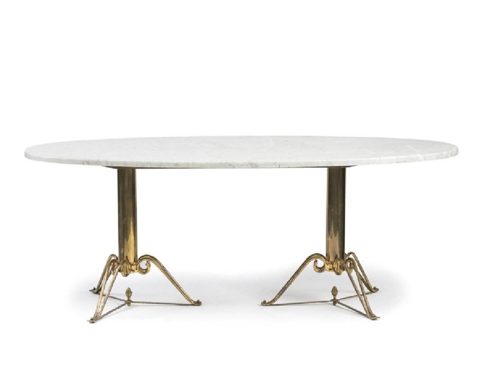 The oval white marble-top raised on two brass tripodal pedestal bases, circa 1970s
Measures: 29.75