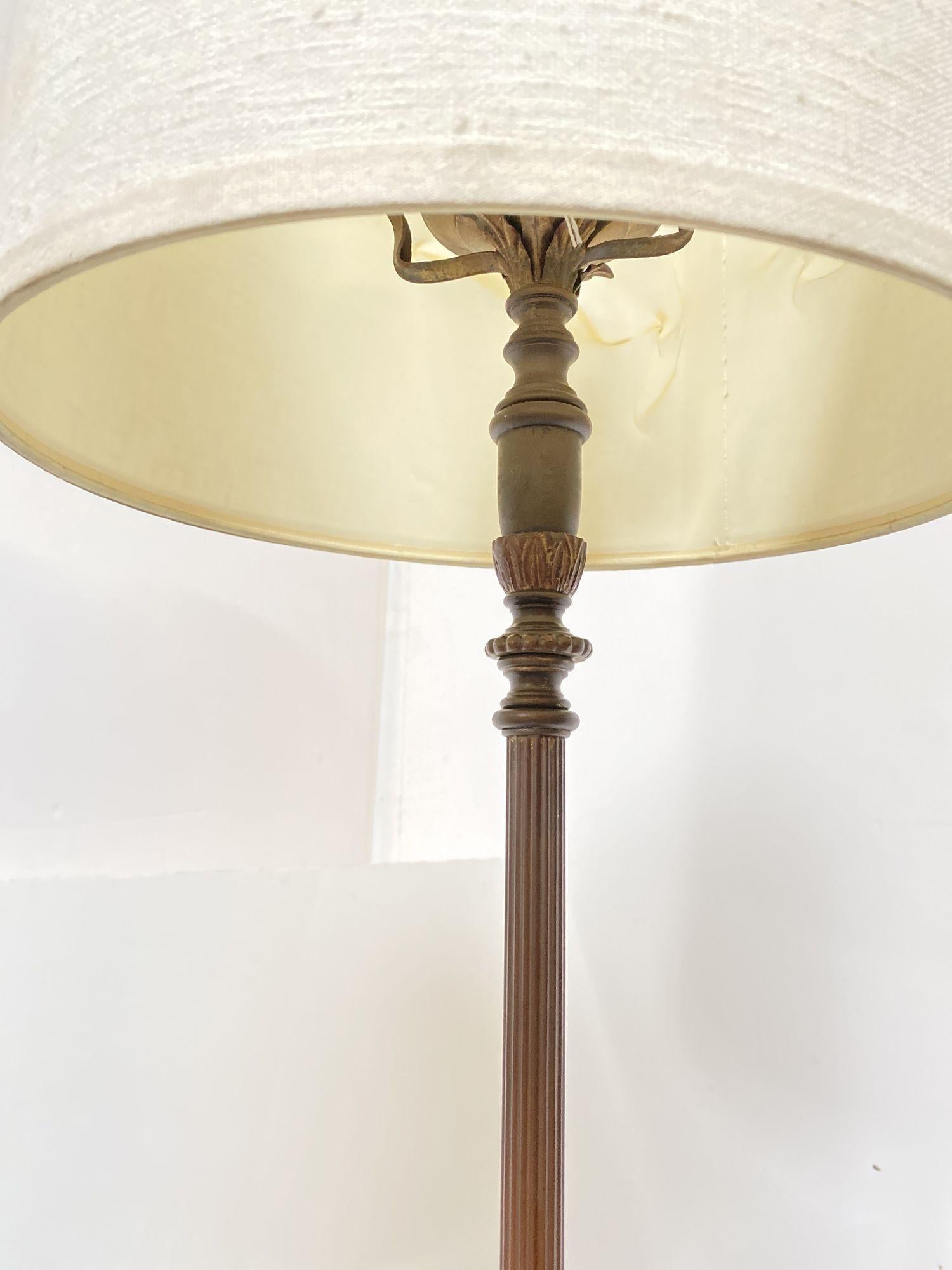 Regency brass floor with bottom marble accented base and fluted center column. The lamp comes with white shade.
 
Circa 1930