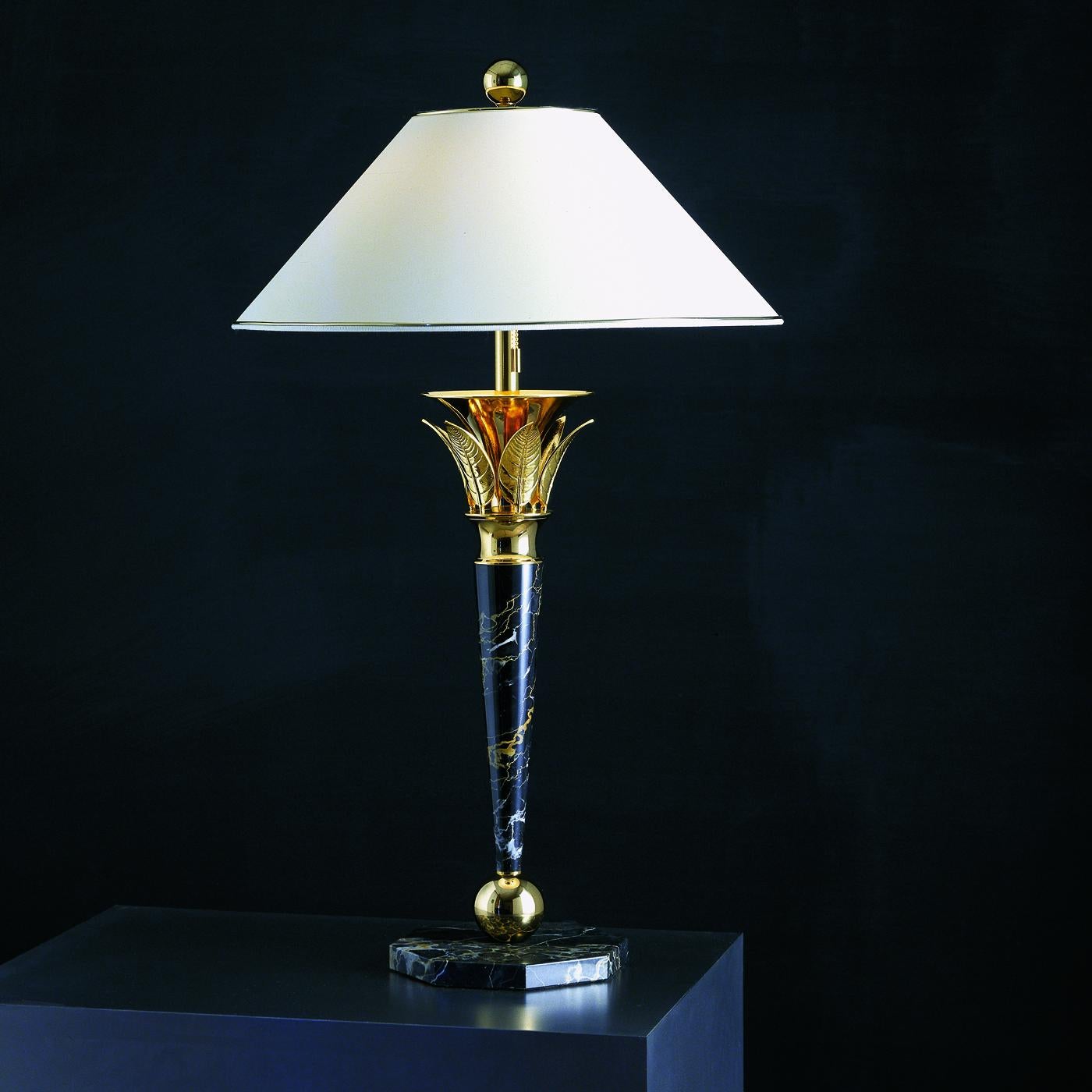 Designed with a sleek silhouette that channels Art Deco style, this meticulously handcrafted table lamp will radiate elegance in a living room, entryway, or private studio desk in midcentury and classic interior decors. The white silk coolie shade