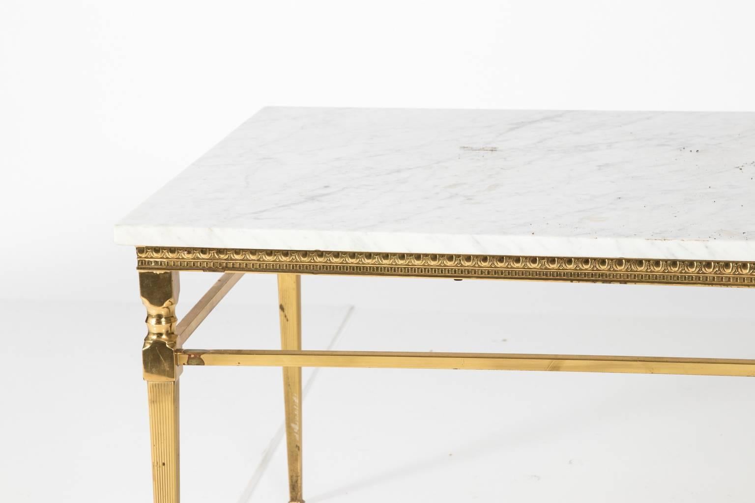 Contemporary marble top coffee table with a polished brass frame that features egg-and-dart with Greek key trim.
 