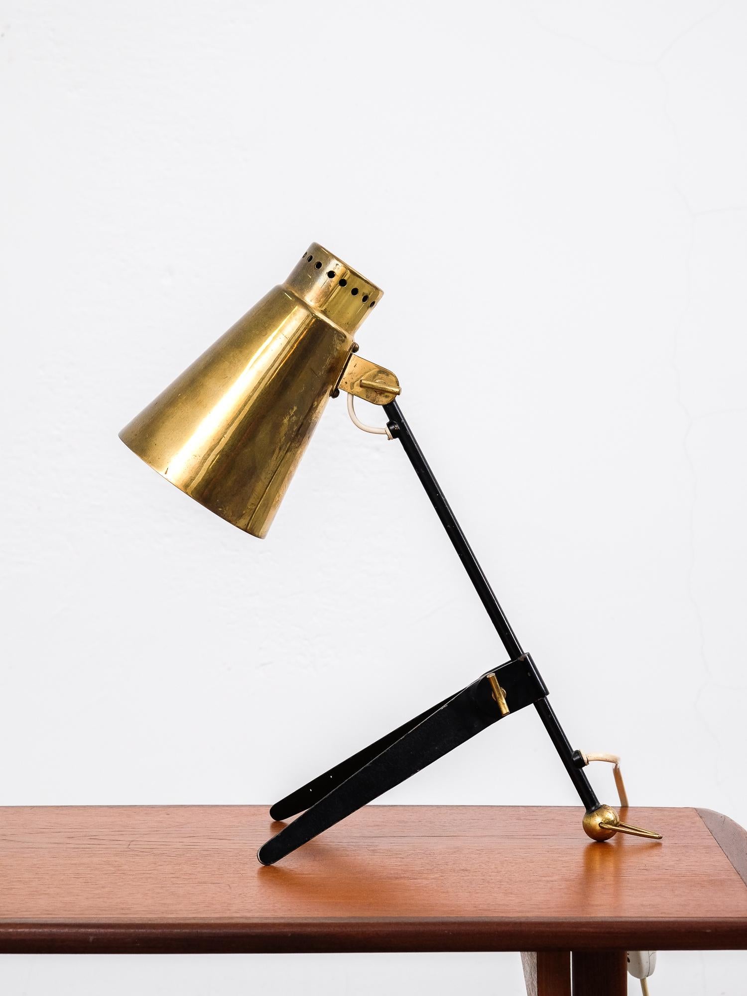 1950s table or wall lamp model 'EV70' by Finnish company Itsu. The lamp is made of a black lacquered metal base with a brass shade. The lamp rests on a brass ball with ring, which can also be used to hang the lamp from the wall.
A very rare lamp
