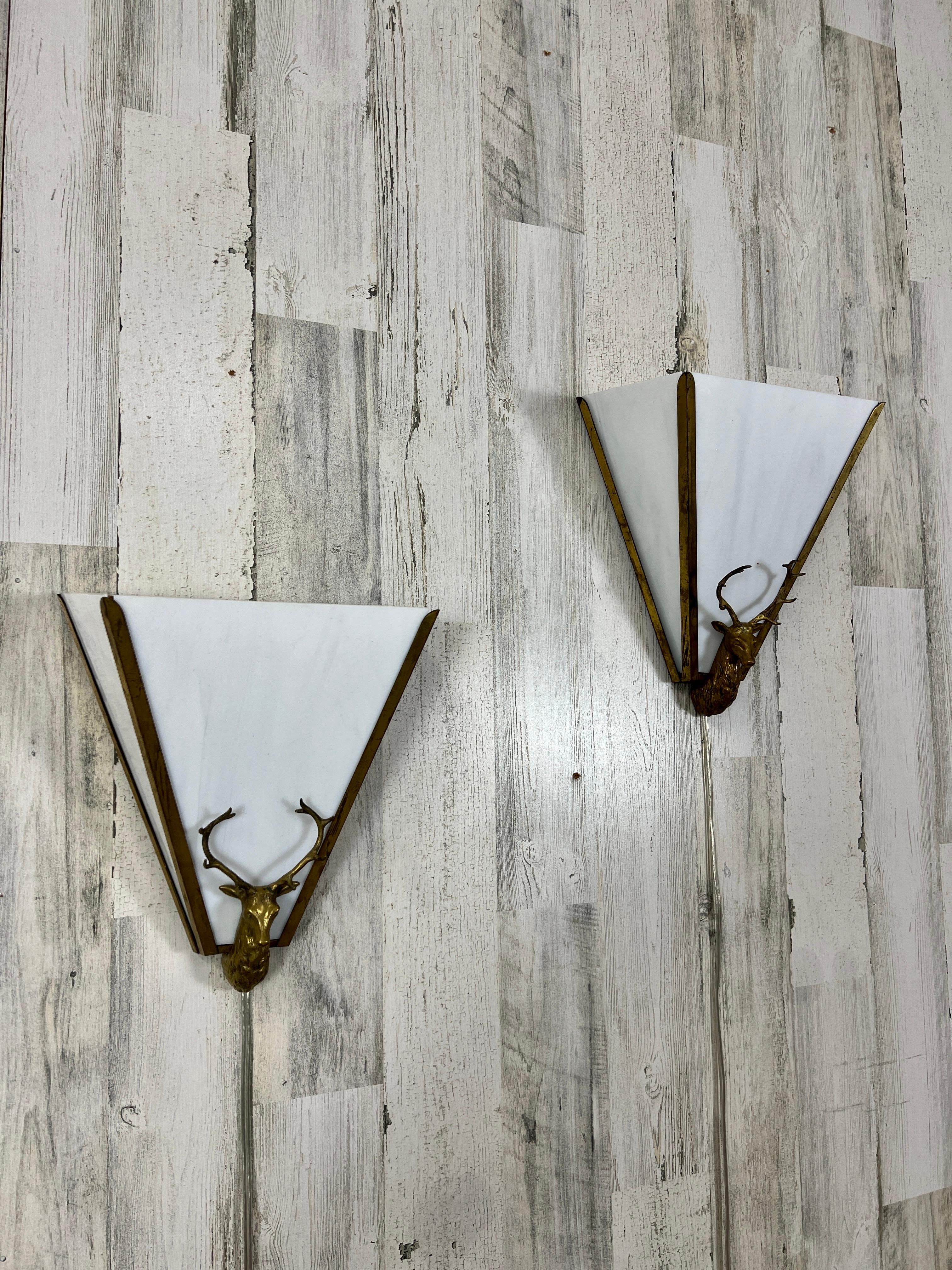 Very dramatic angled slip shade sconces with glass and brass deer head mounted on the front.